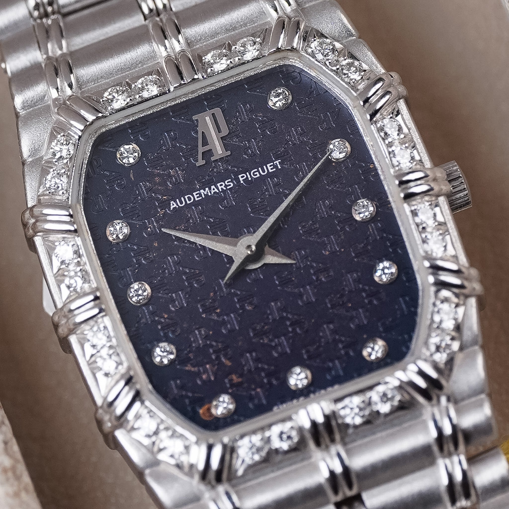 A closeup of a white gold Audemars Piguet Bamboo vintage watch with a blue textured dial, diamond hour markers, white gold hands, and a diamond bezel. 
