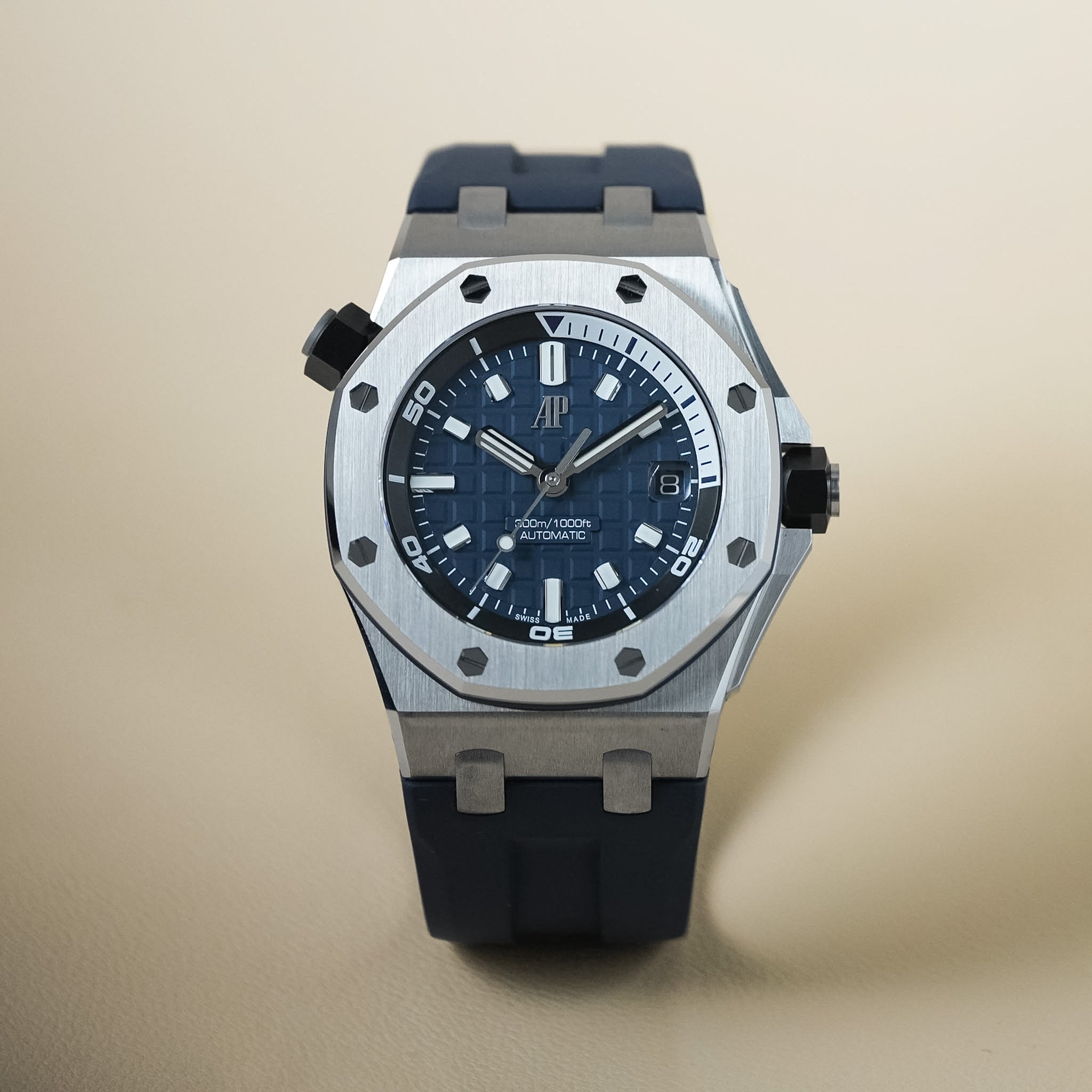 An Audemars Piguet Royal Oak Offshore Diver in navy blue with a steel case and rubber strap shot on a neautral cream background