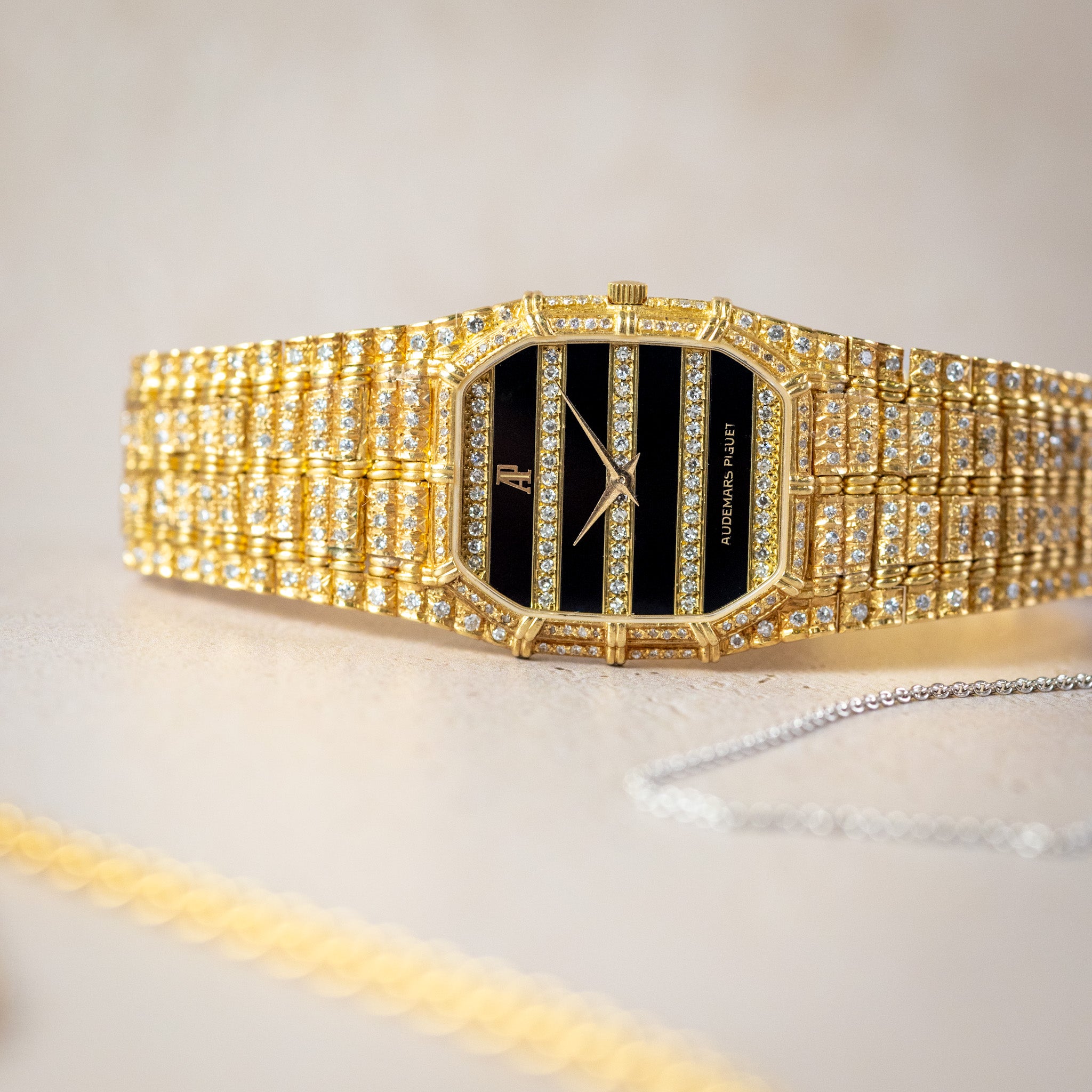 Gold watch with black face on a light background