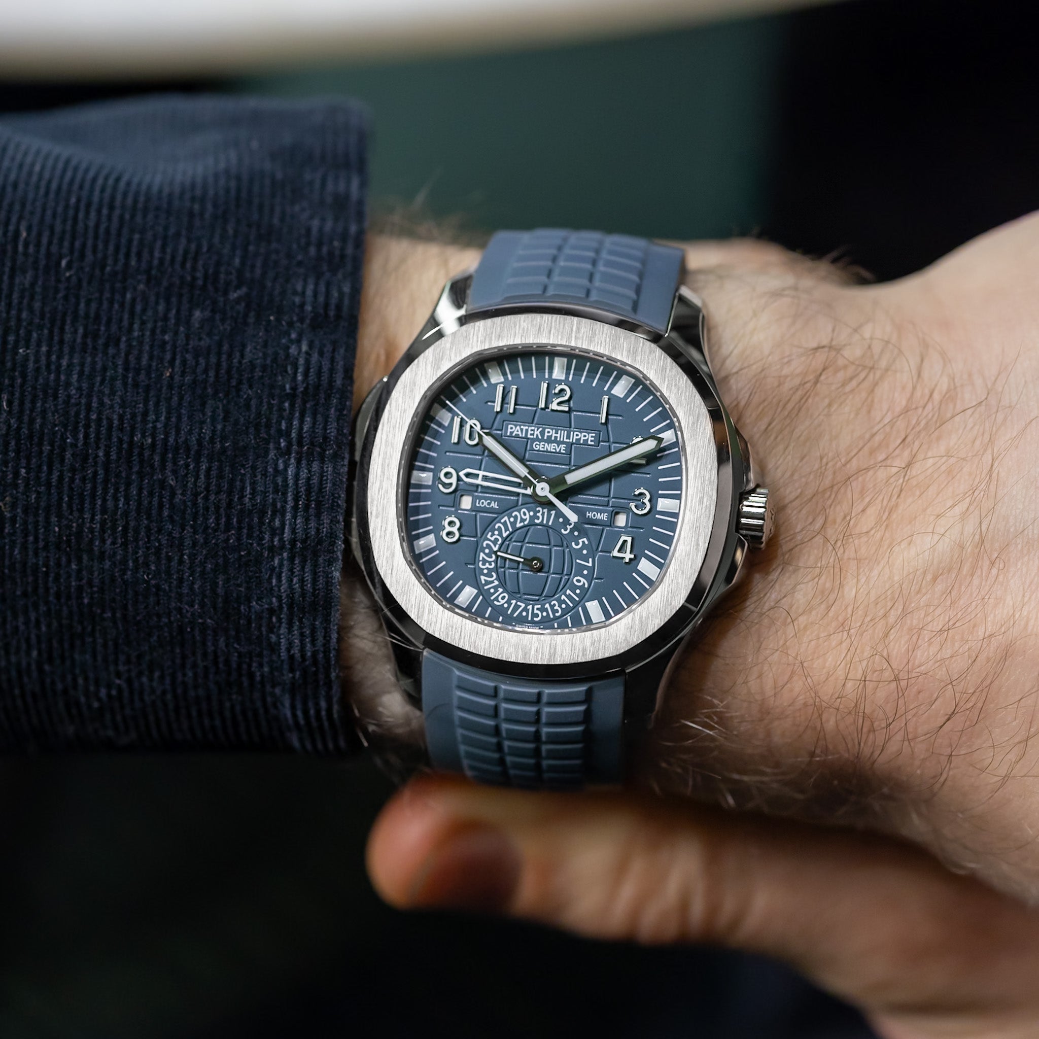 Blue watch with detailed face on a wrist, brand visible