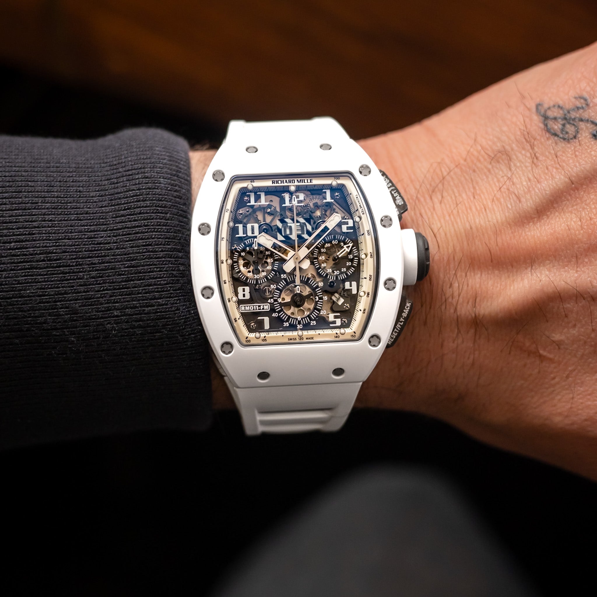 Luxury watch on a person's wrist with a dark background