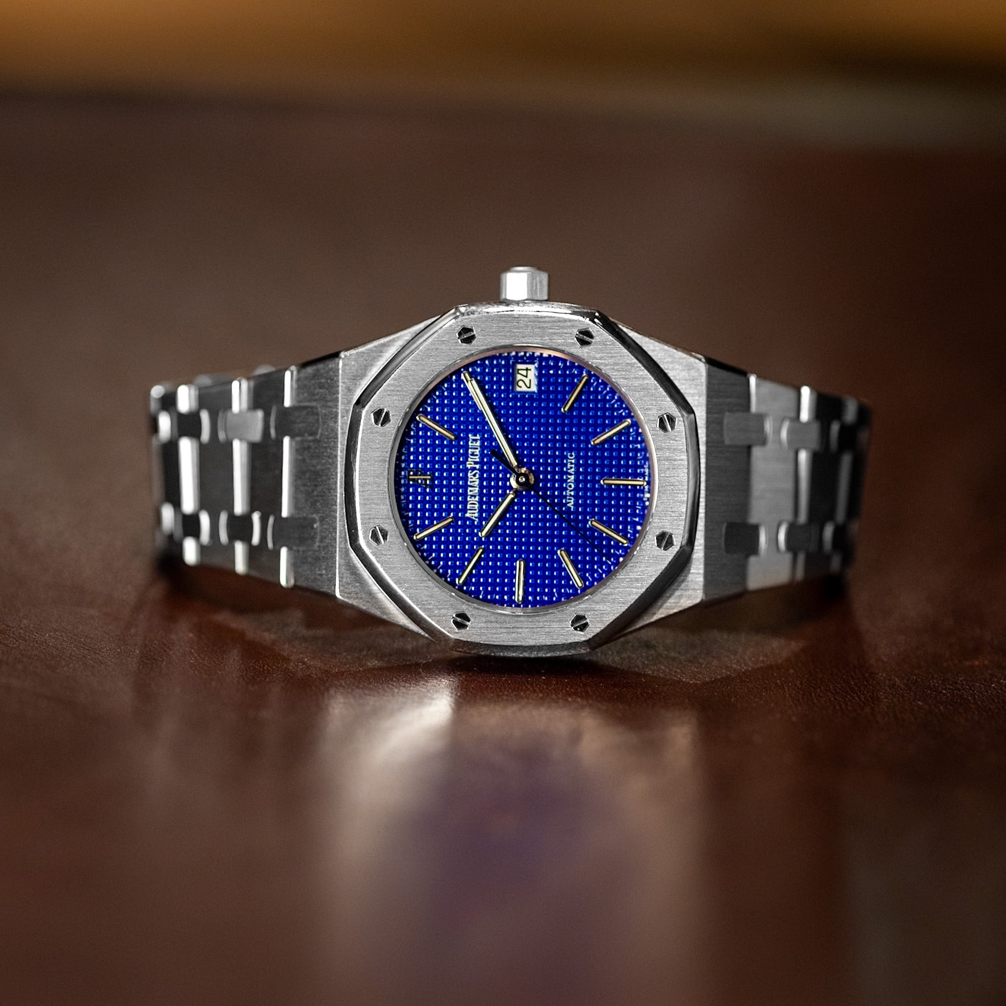 Silver watch with a blue face on a brown surface