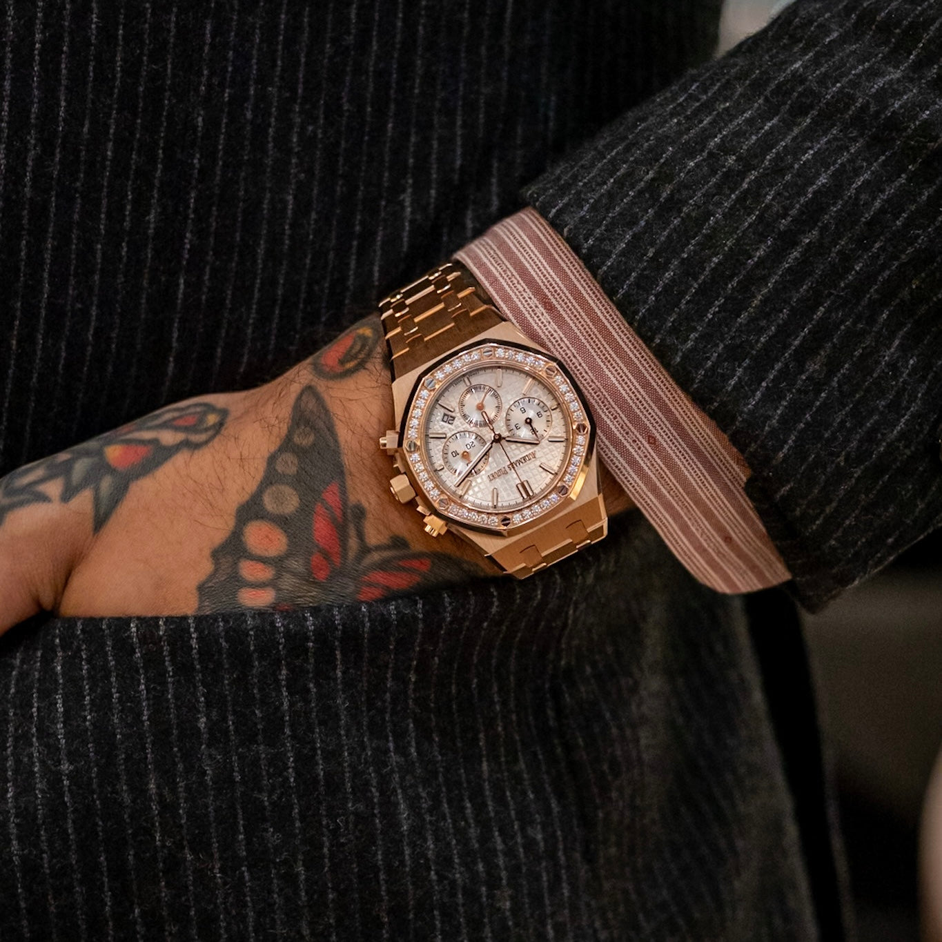 Audemars Piguet Royal Oak Chronograph 26715OR in 18k rose gold with diamond-set bezel, silver “Grande Tapisserie” dial, integrated rose gold bracelet on wrist.