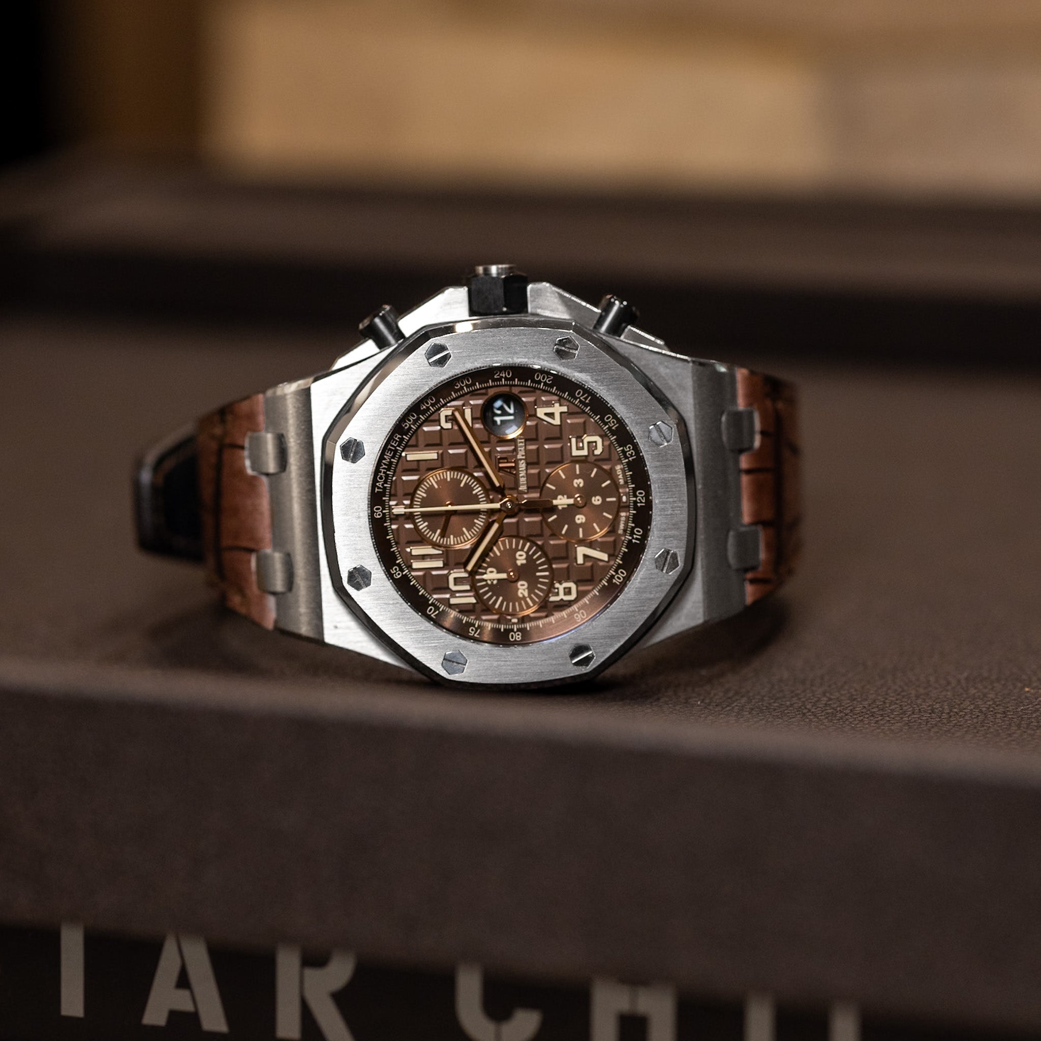 Luxury watch with brown leather strap on a wooden surface