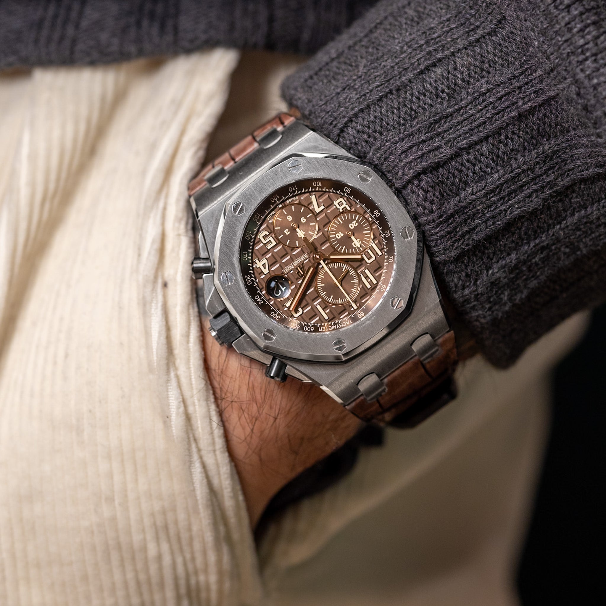 Luxury watch with brown leather strap worn on a wrist.