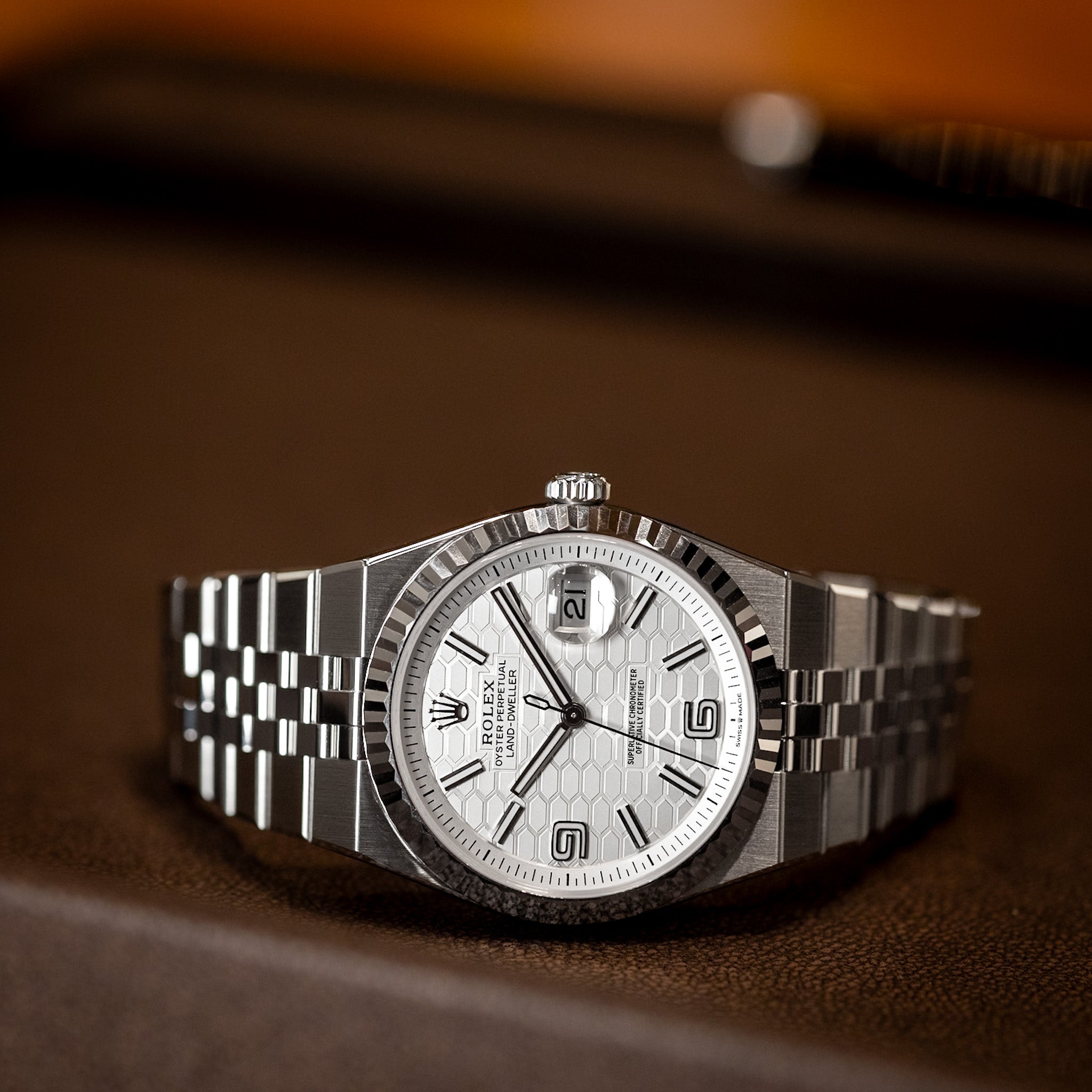 Silver watch with a white face on a brown surface