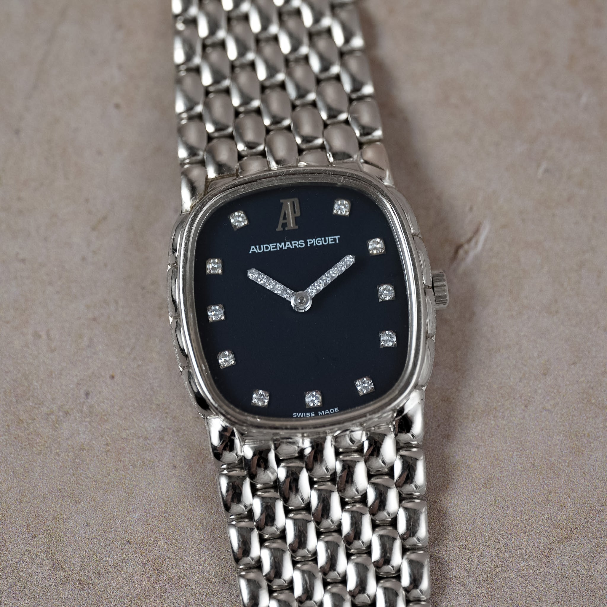 Audemars Piguet women's watch featuring a silver-toned stainless steel link bracelet and a dark navy blue dial with diamond hour markers.