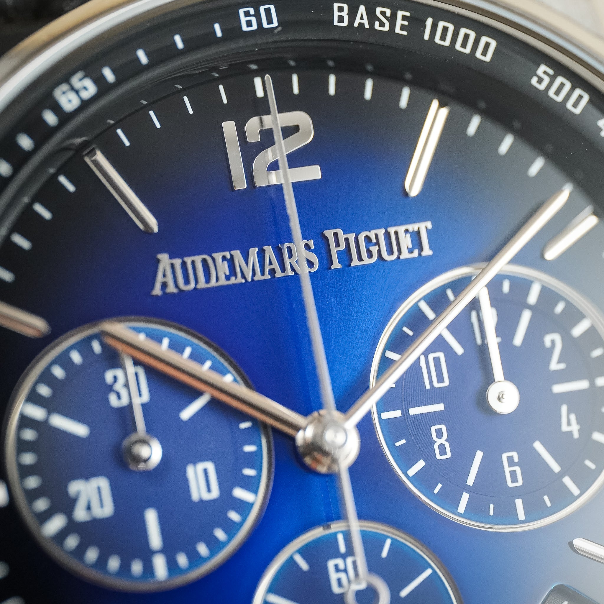 Close-up of an Audemars Piguet watch dial with a deep blue gradient face, silver-tone hands and markers, and subdials.