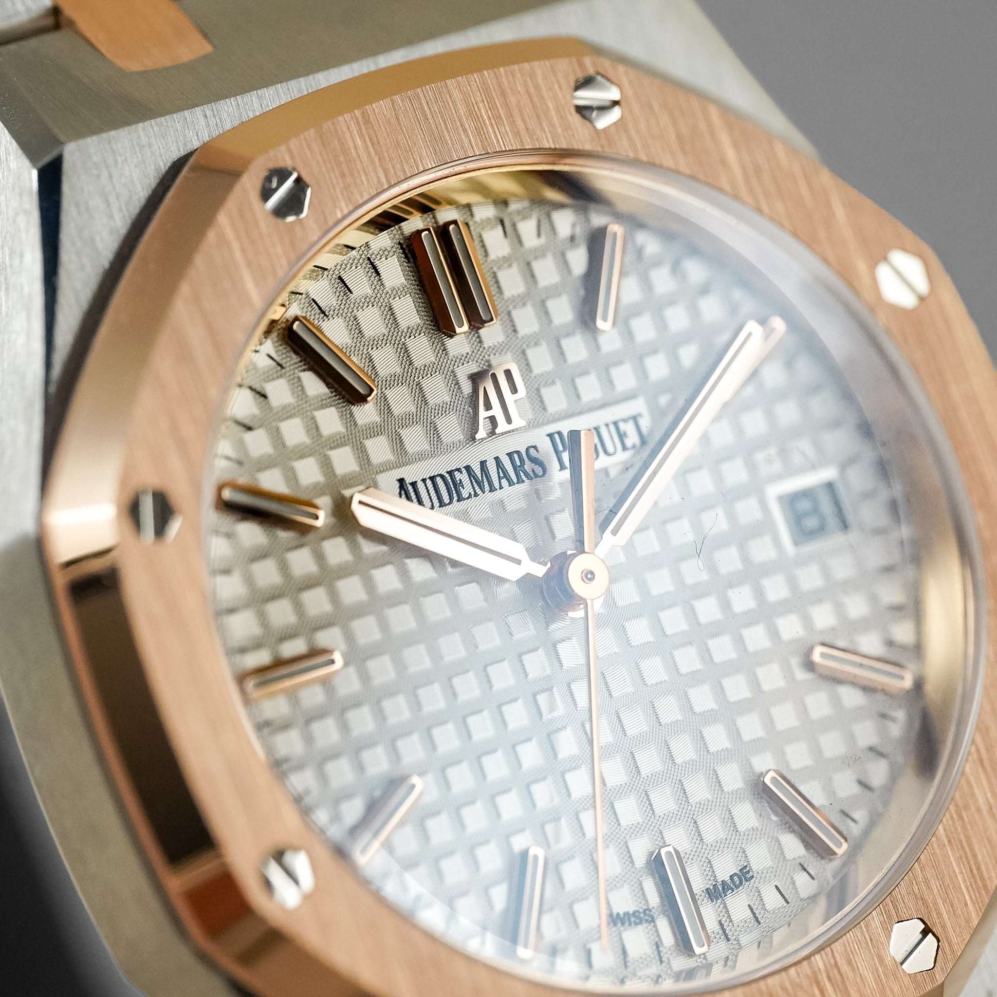Close-up of an Audemars Piguet watch featuring a rose gold octagonal bezel, a textured silver-white dial, and matching rose gold hands and hour markers.
