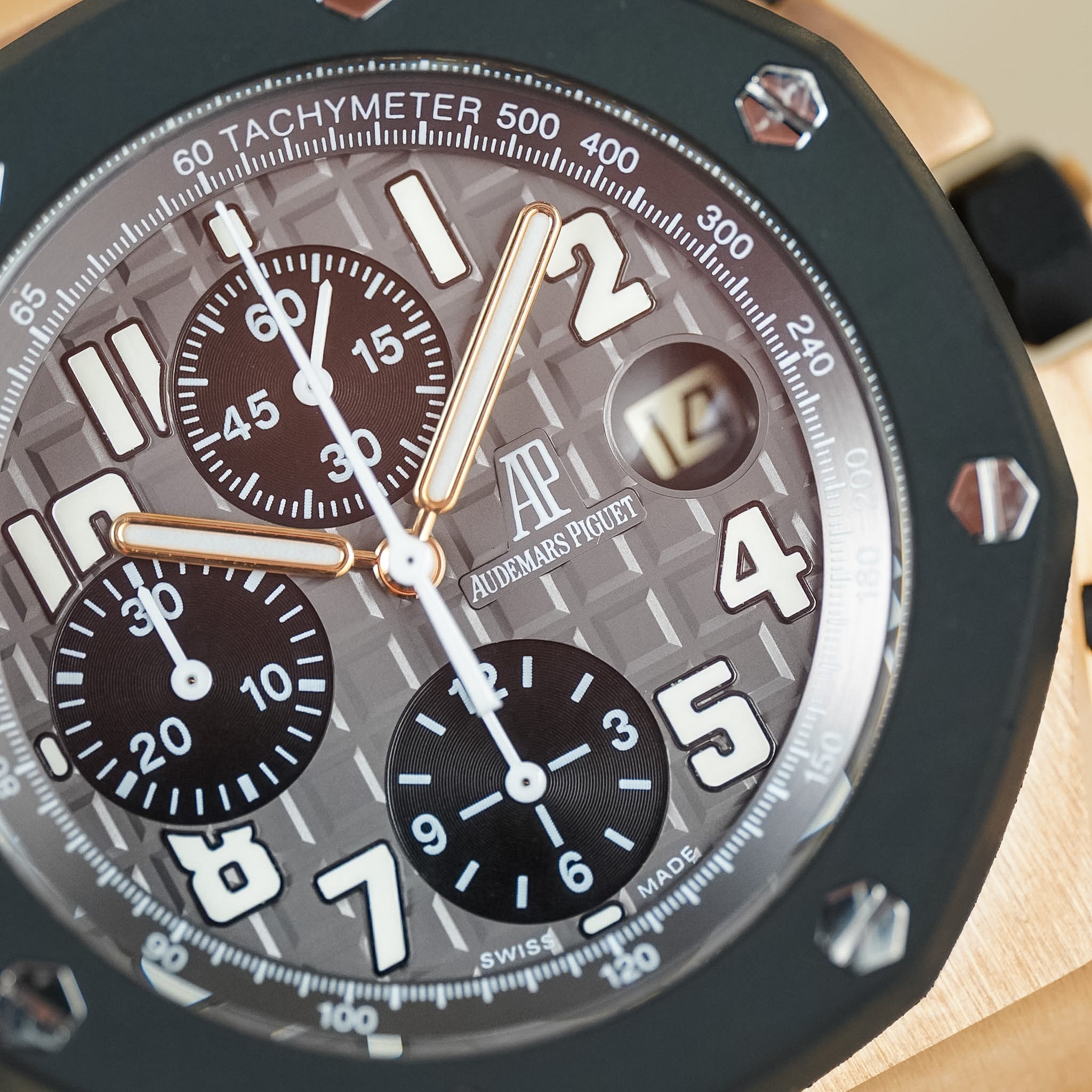 Close-up of an Audemars Piguet Royal Oak Offshore Chronograph with a rose gold case, black ceramic bezel, textured dial with chronograph subdials