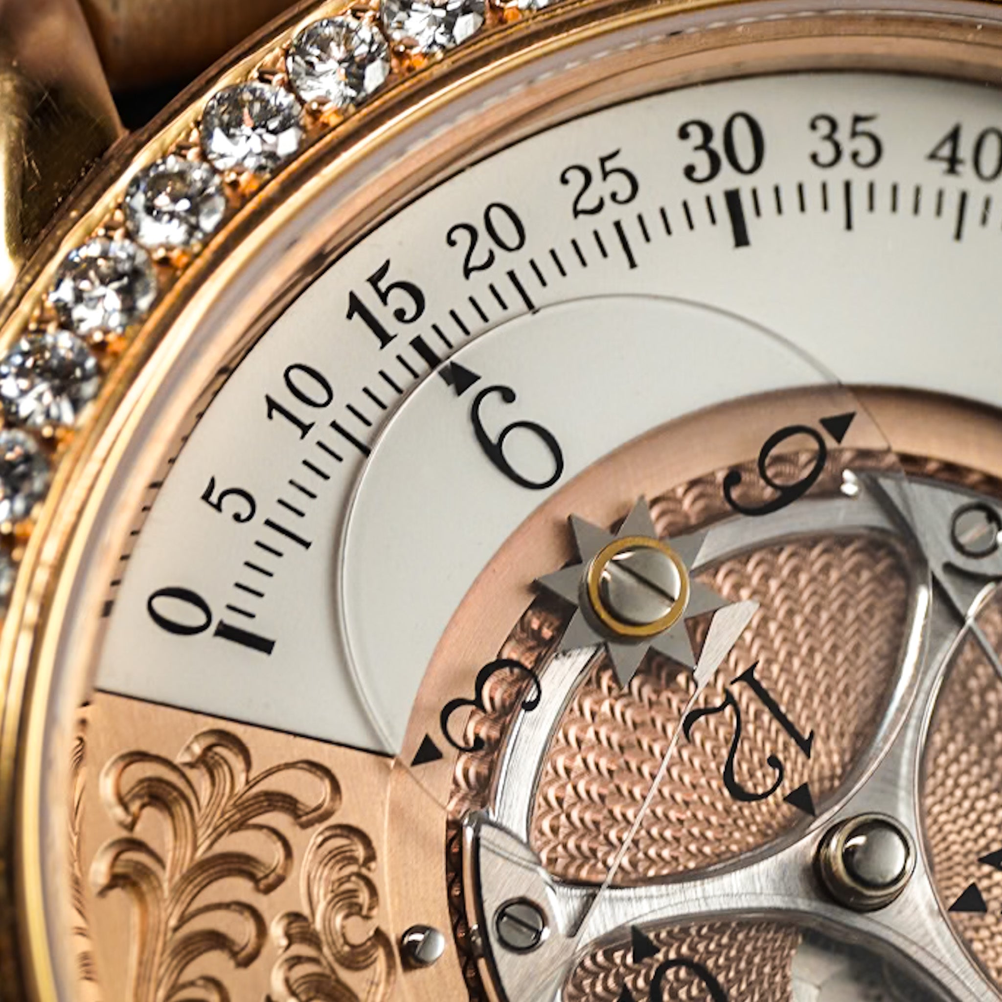 Close-up of a luxury watch dial showing a rose gold case, white hour markers, a crystal gemstone bezel, and intricate mechanical gears.