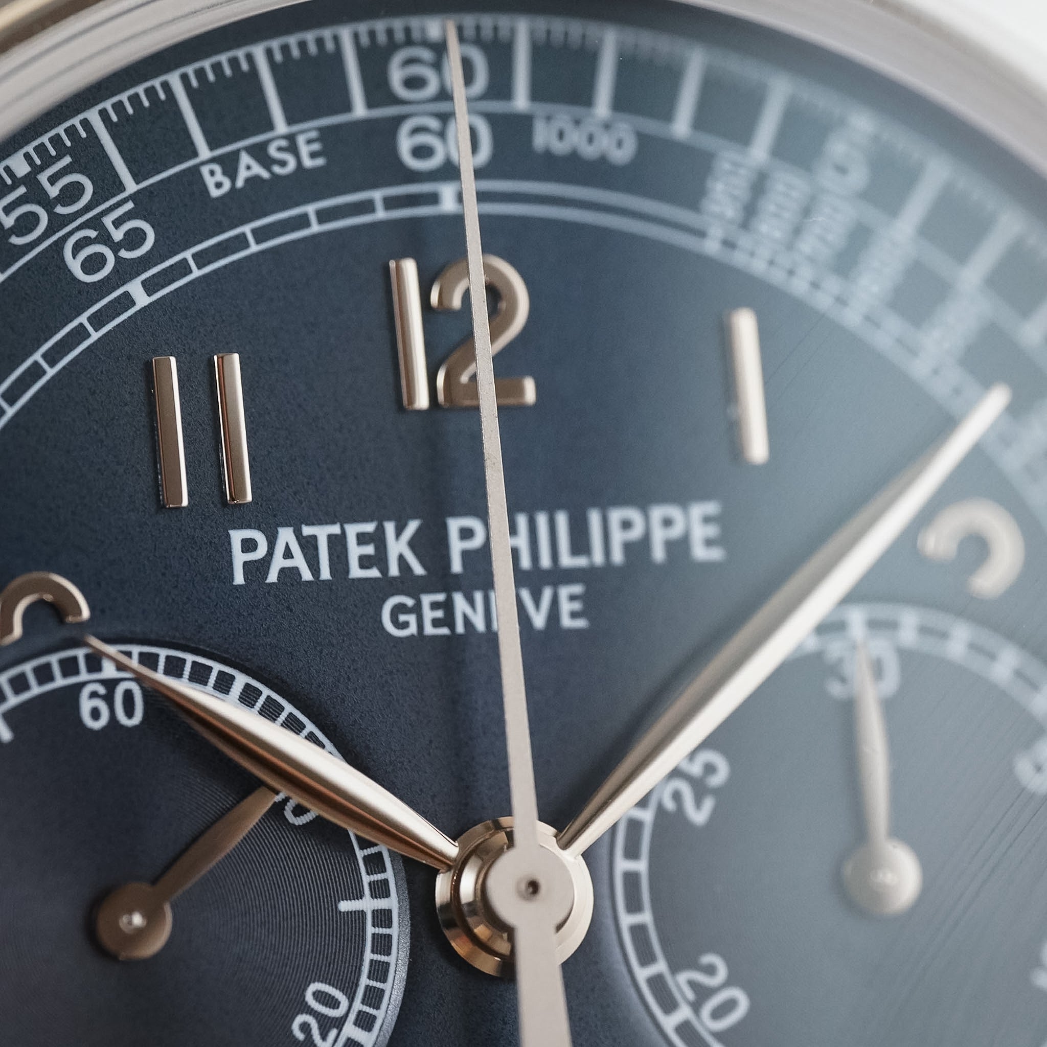 A close-up photo of a Patek Philippe chronograph with a blue dial and white gold numerals with detailed subdials.