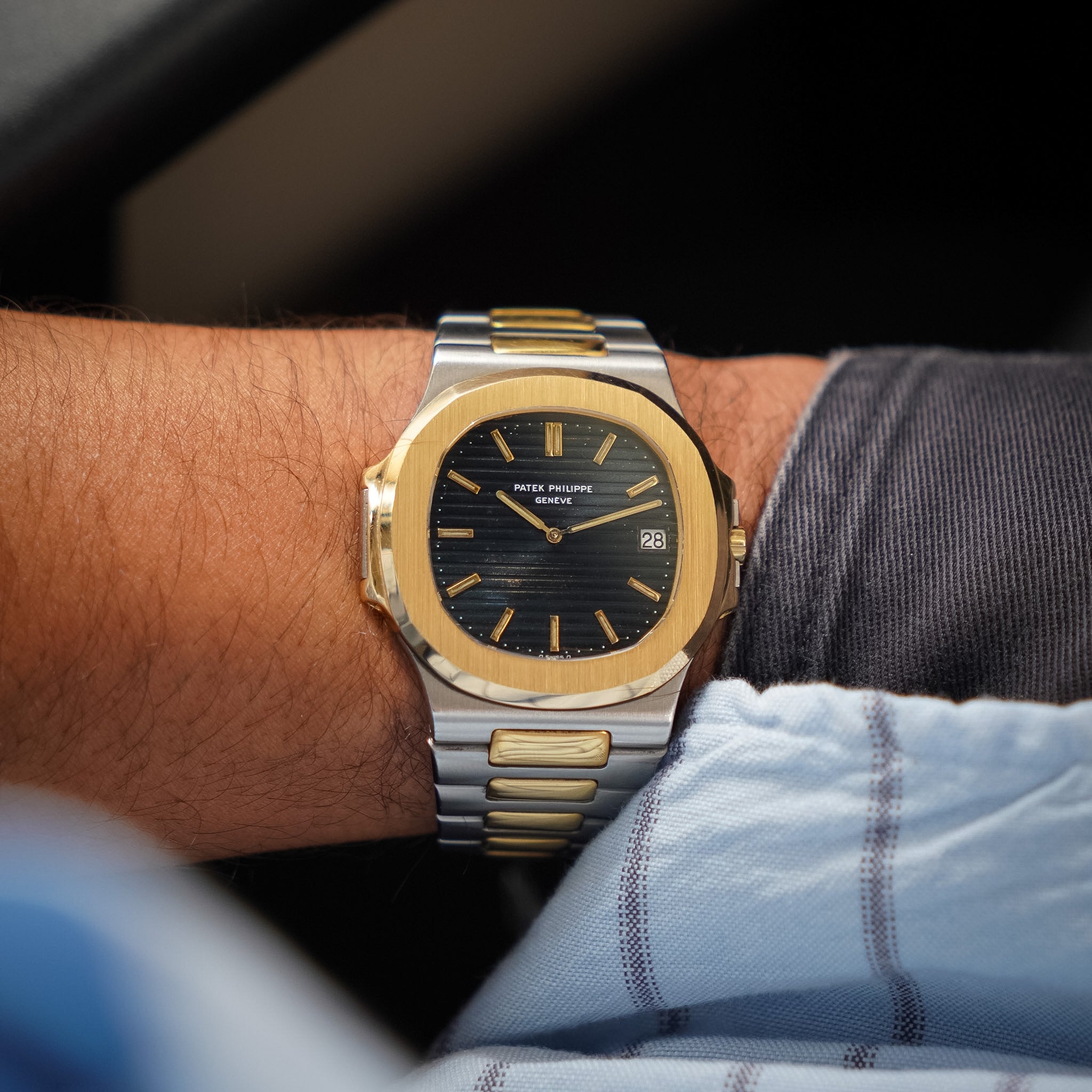 A Peter Millar Nord watch with a gold and silver two-tone stainless steel case and bracelet, featuring a black dial, worn on a person's wrist.