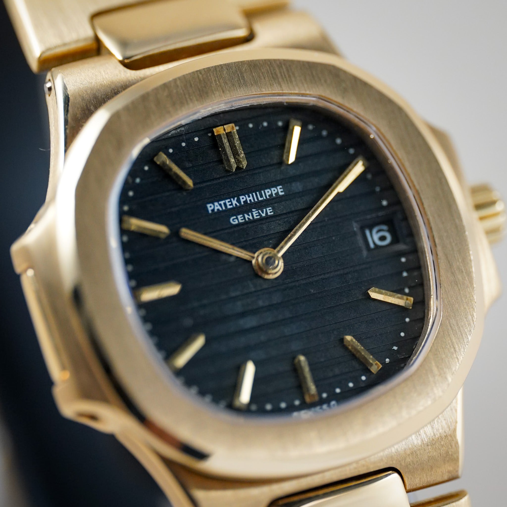 Closeup of a ladies Patek PHilippe Nautilus watch with a yellow gold case and bracelet, blue dial