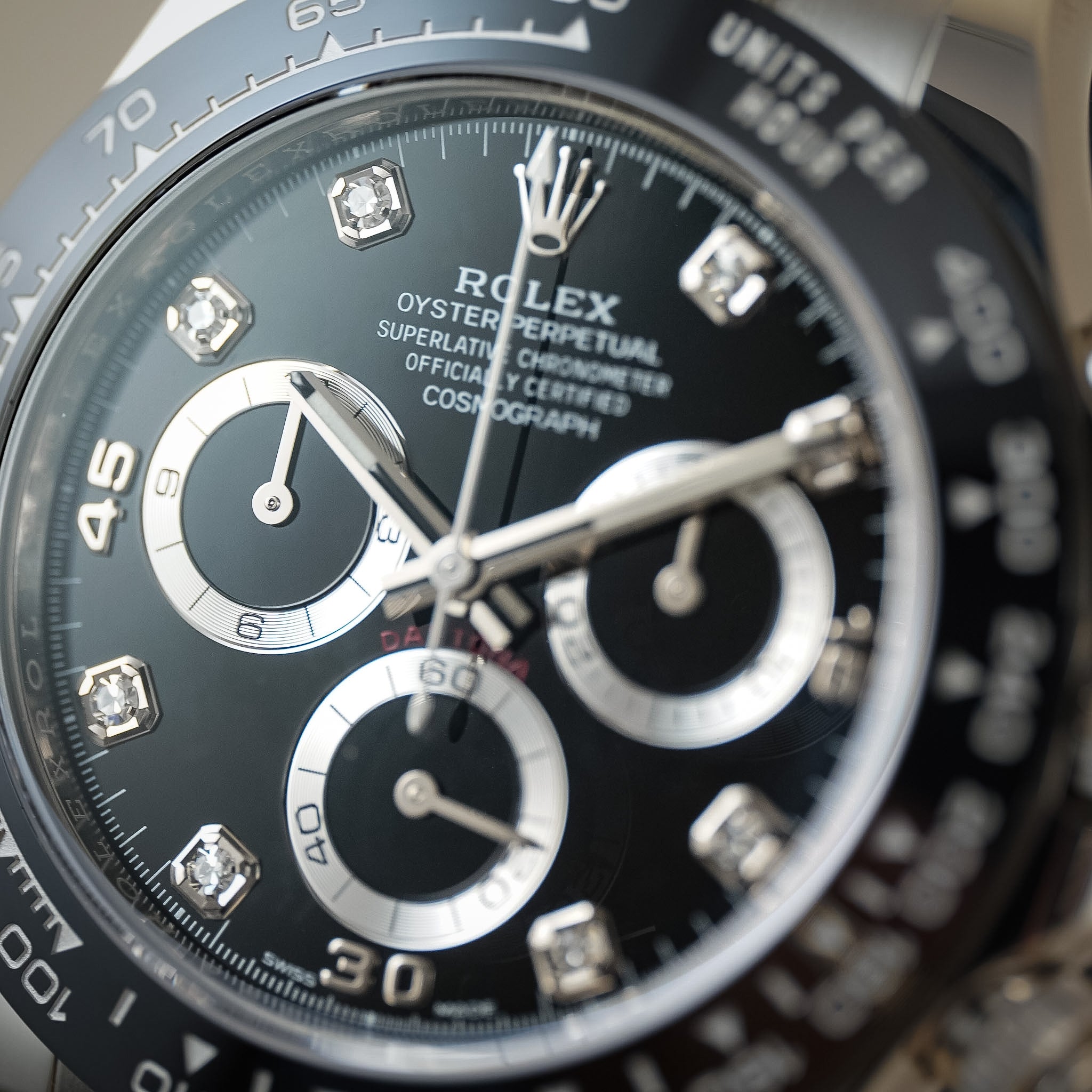 Close-up of a Rolex Submariner Cosmograph Daytona watch with a black dial, silver bezel, and diamond hour markers.
