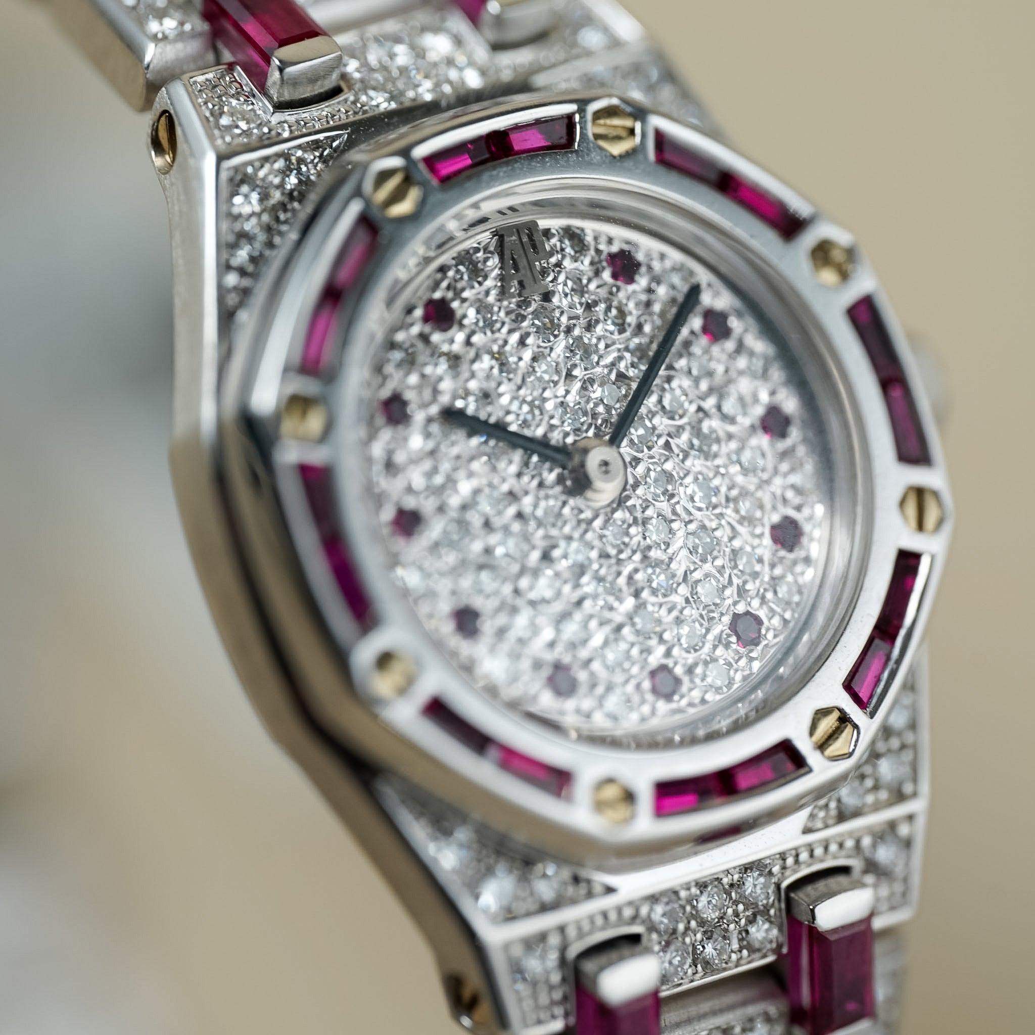 Luxury watch with diamond and ruby accents on a blurred background