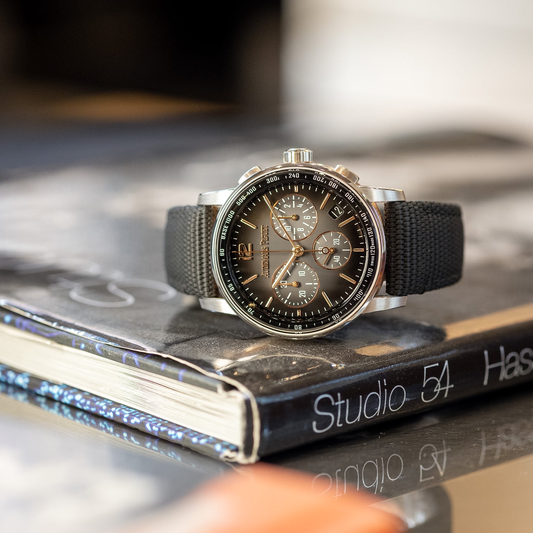 Chronograph watch with a black strap on a book titled 'Studio 54'.