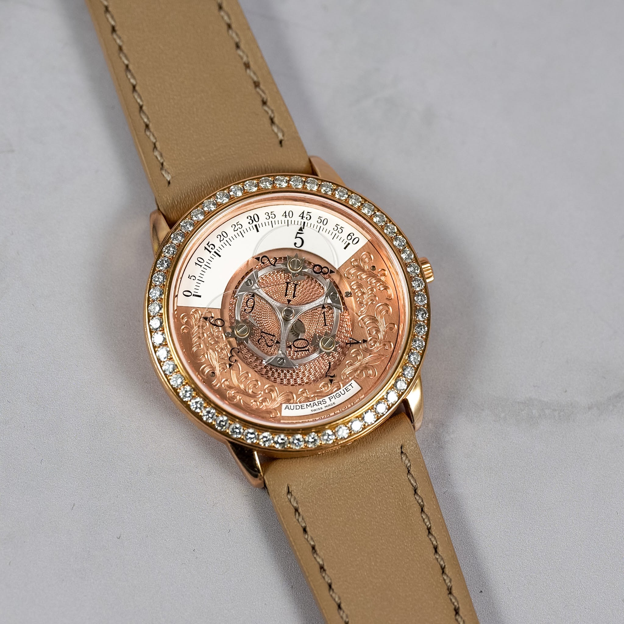 A luxury watch with a tan leather strap, a rose gold-toned case, and a crystal-encrusted bezel. The skeleton dial reveals intricate mechanical gears and a central dragon graphic.