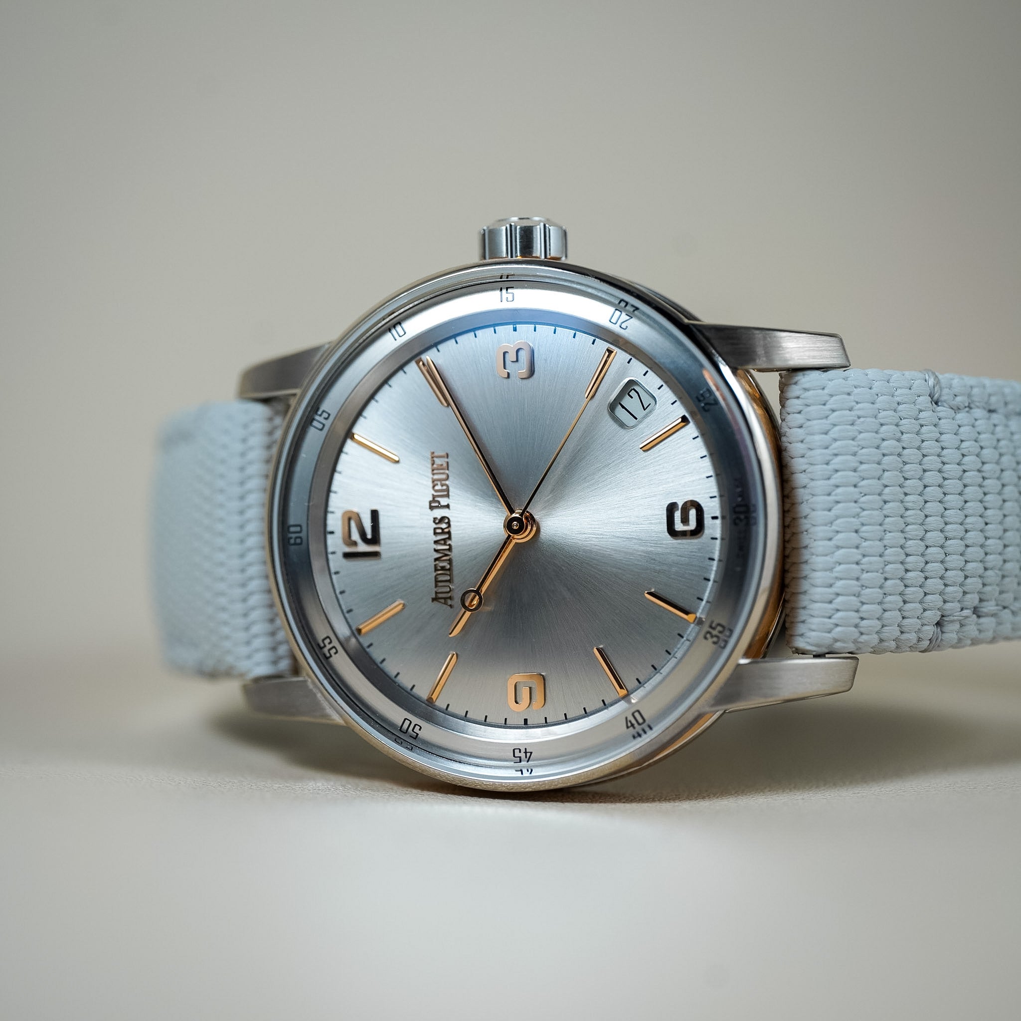 Wristwatch with light blue strap and silver case on a neutral background