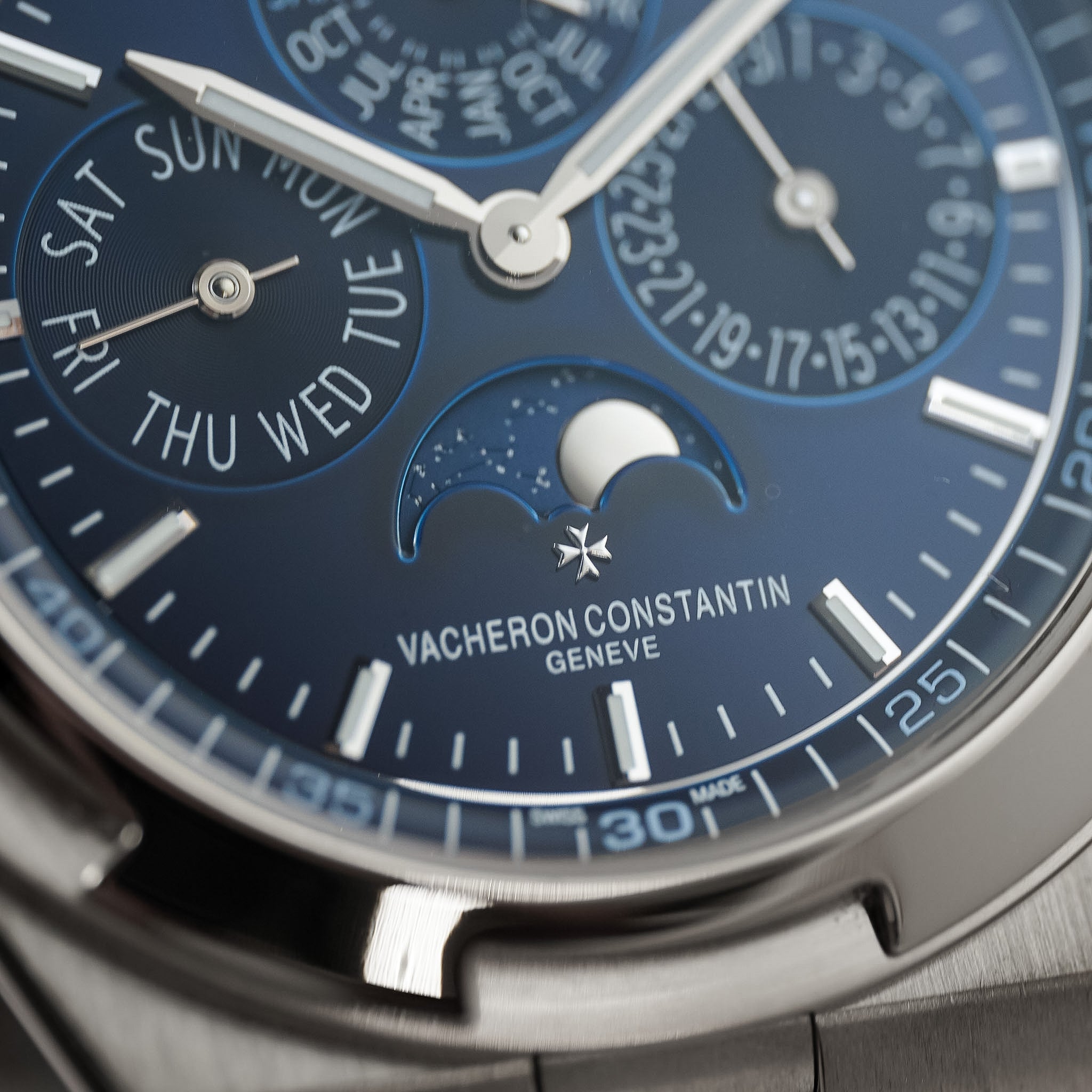 Close-up of a Vacheron Constantin Geneve perpetual calendar watch with a deep blue dial, silver-toned case, and day-of-week subdials.