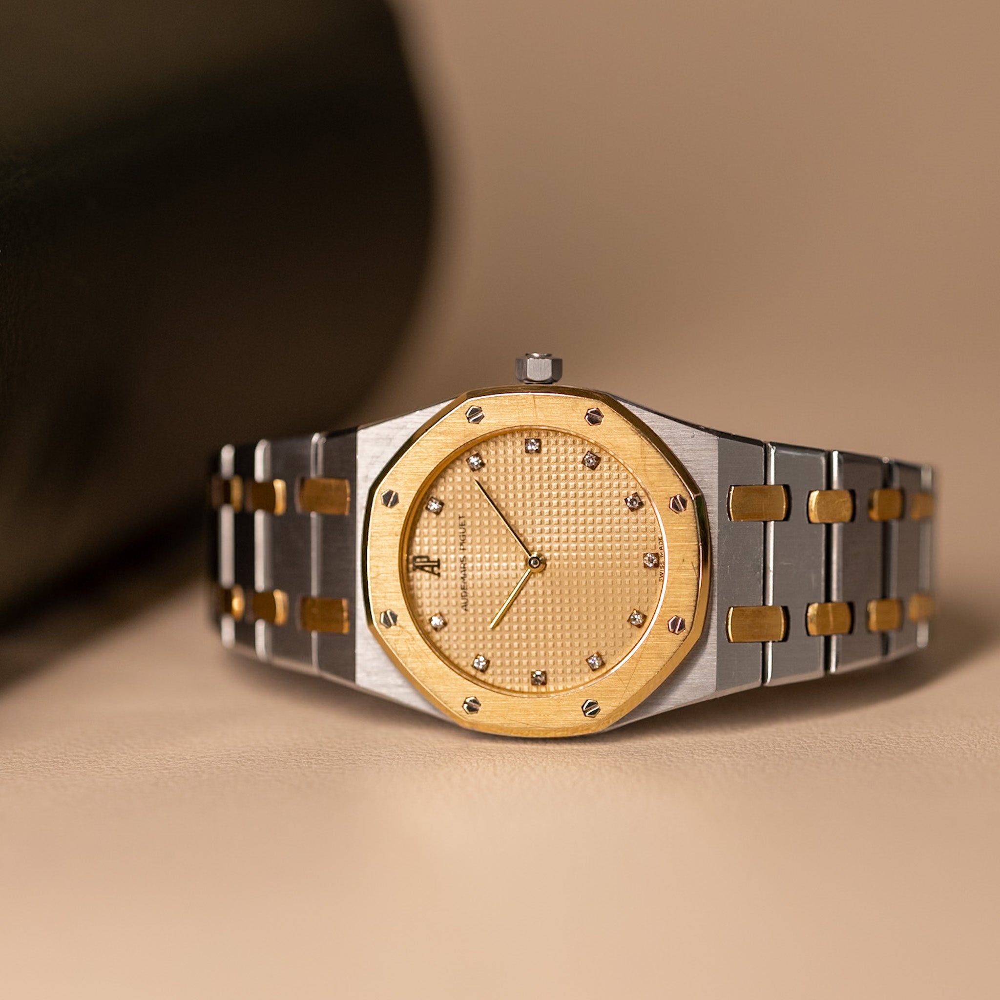 Gold and silver watch on a beige background