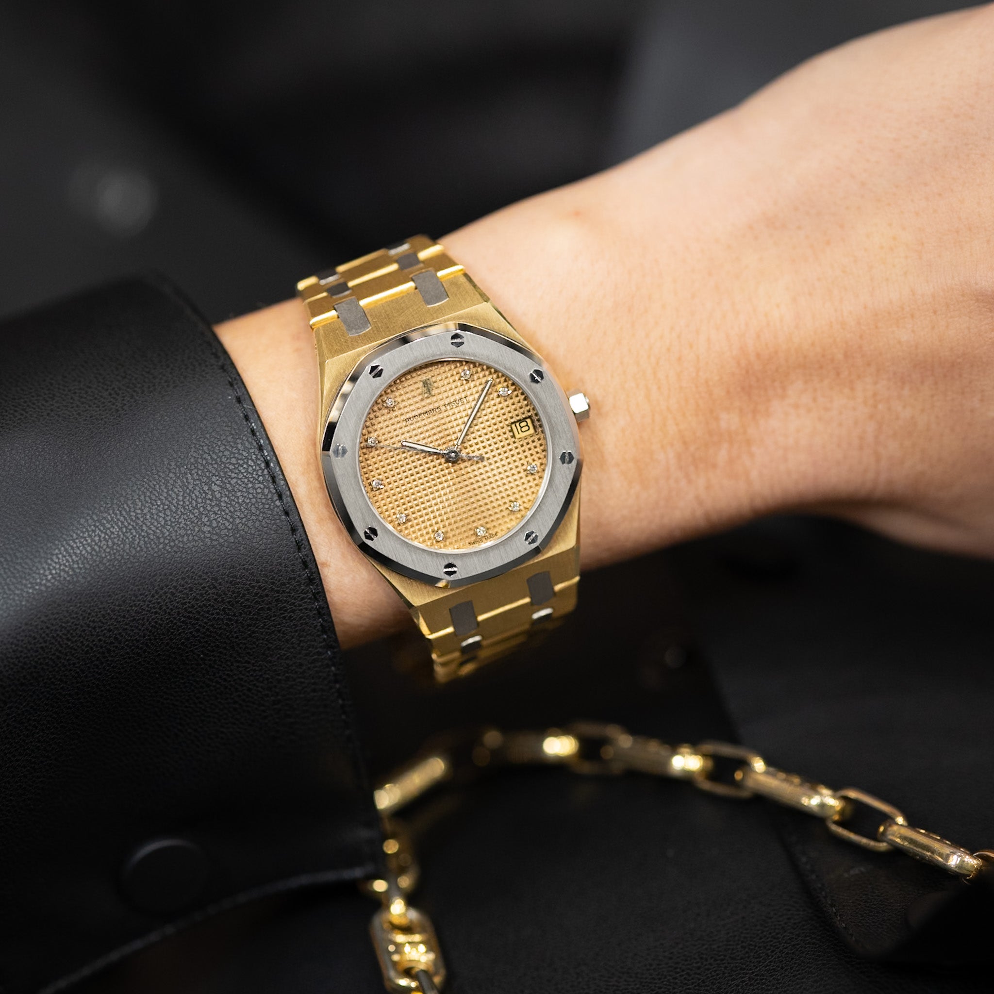Gold watch on a wrist with a blurred background