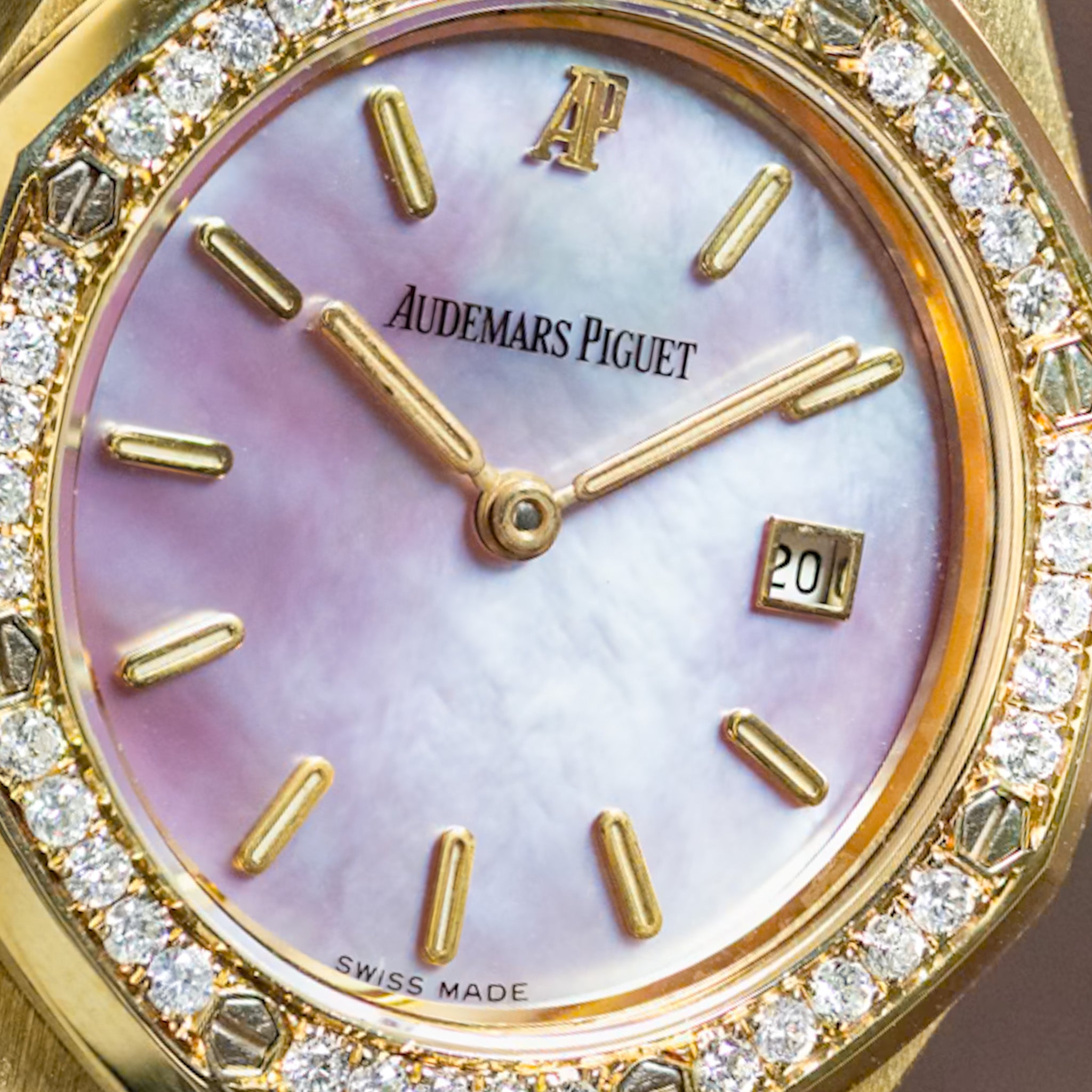 Luxury watch with pink face and gold casing, featuring the brand 'Audemars Piguet'.