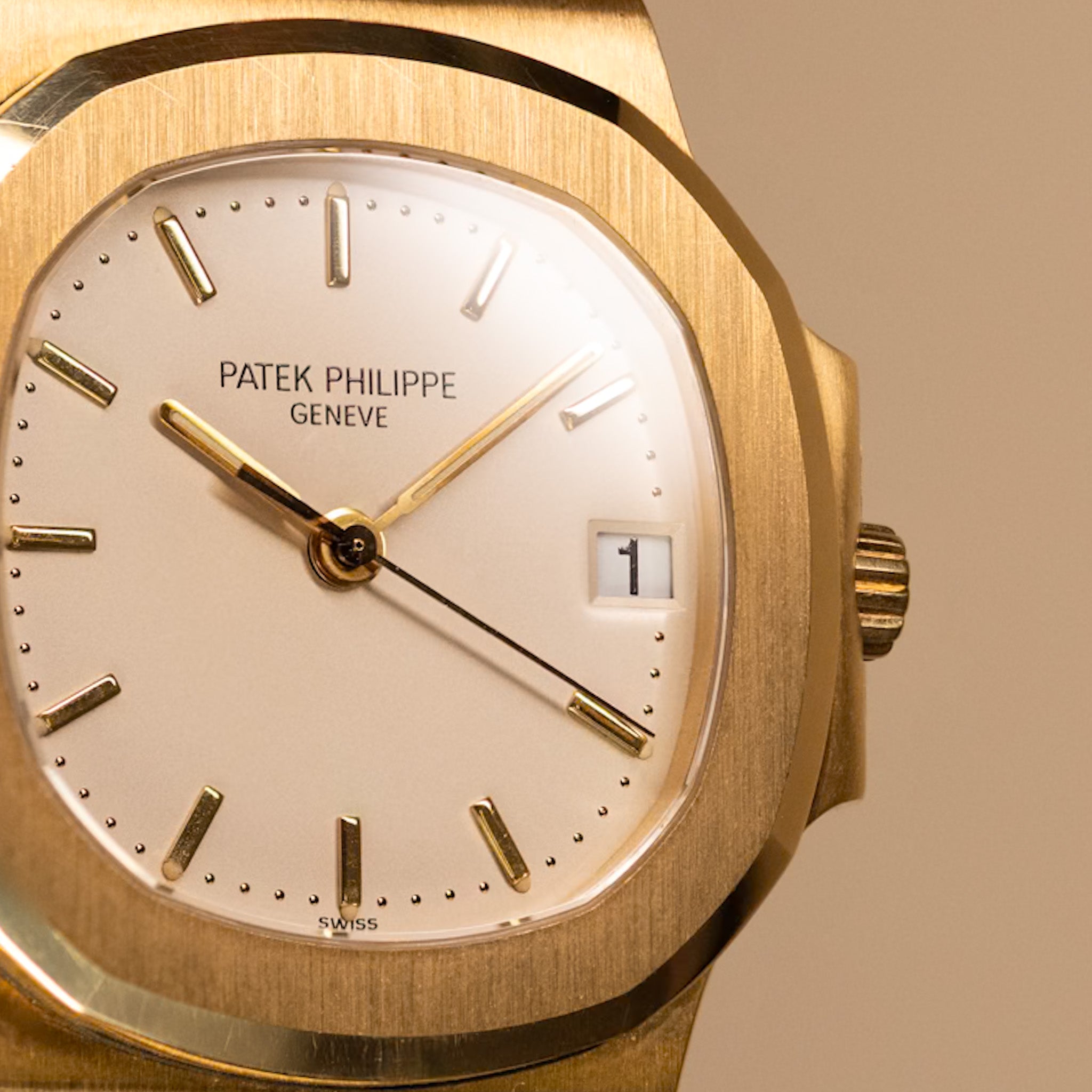 Gold Patek Philippe watch with beige face on a beige background