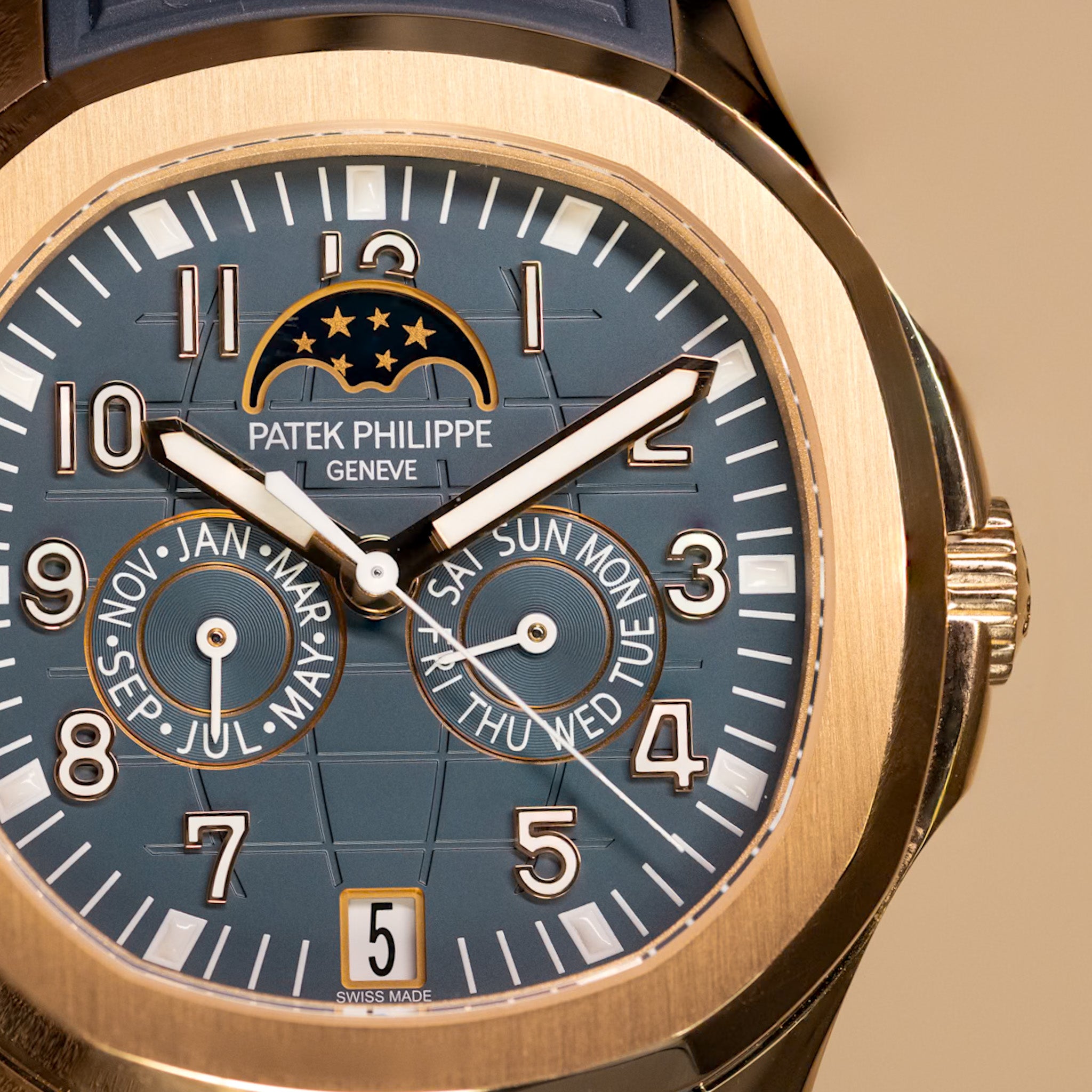 Close up shot of a rose gold complicated watch with a blue dial