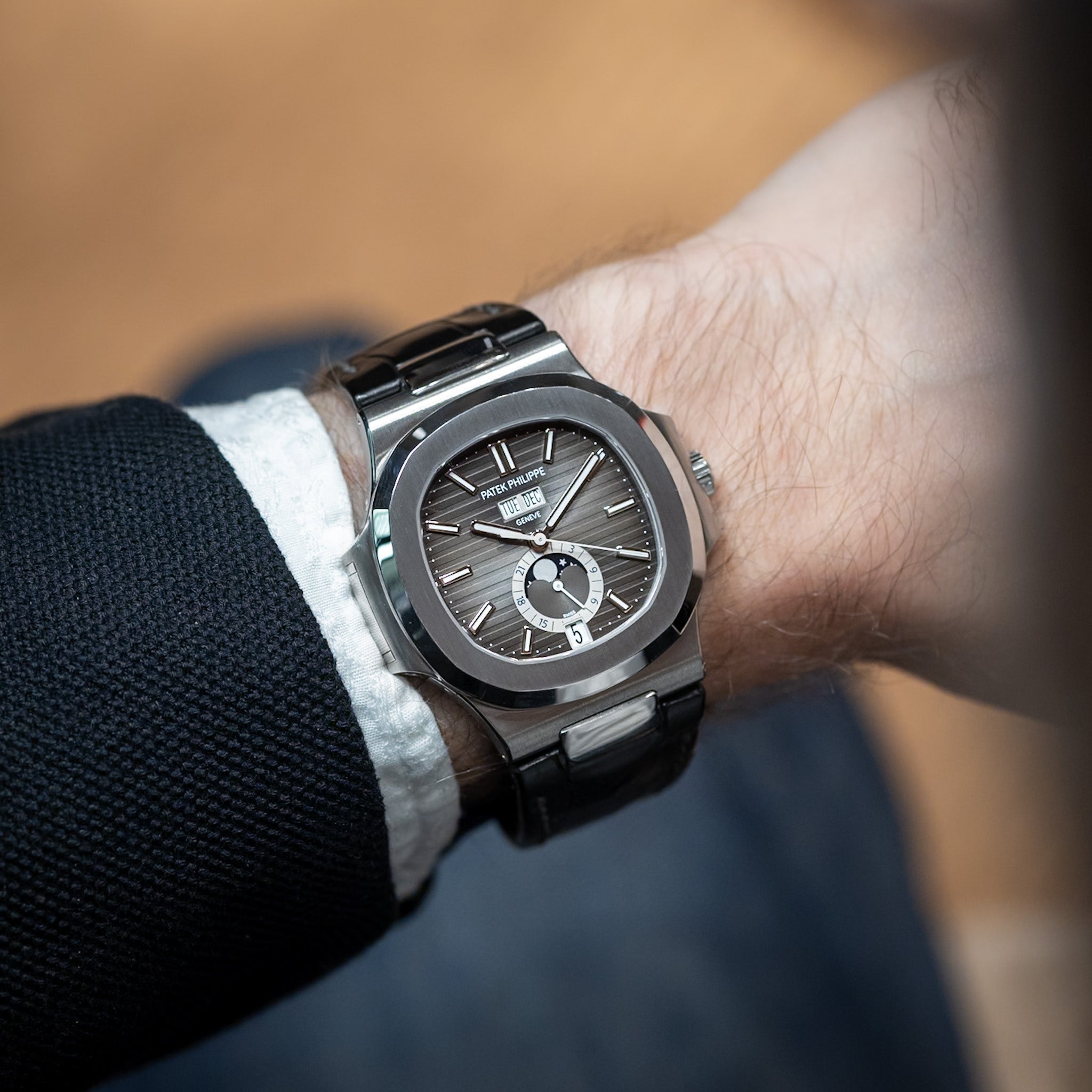 Luxury watch on a person's wrist with a blurred background