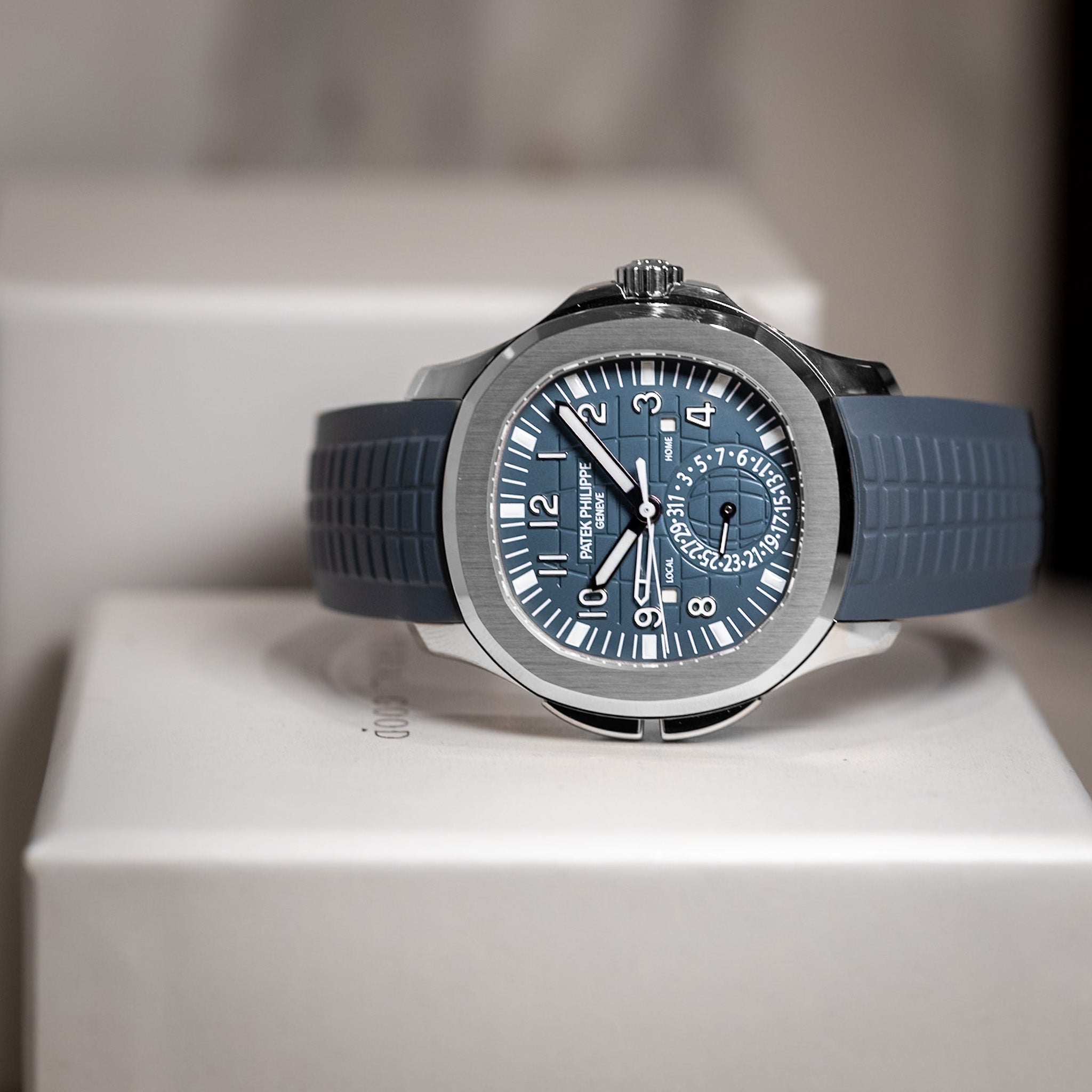 Blue watch with a silver case on a white surface