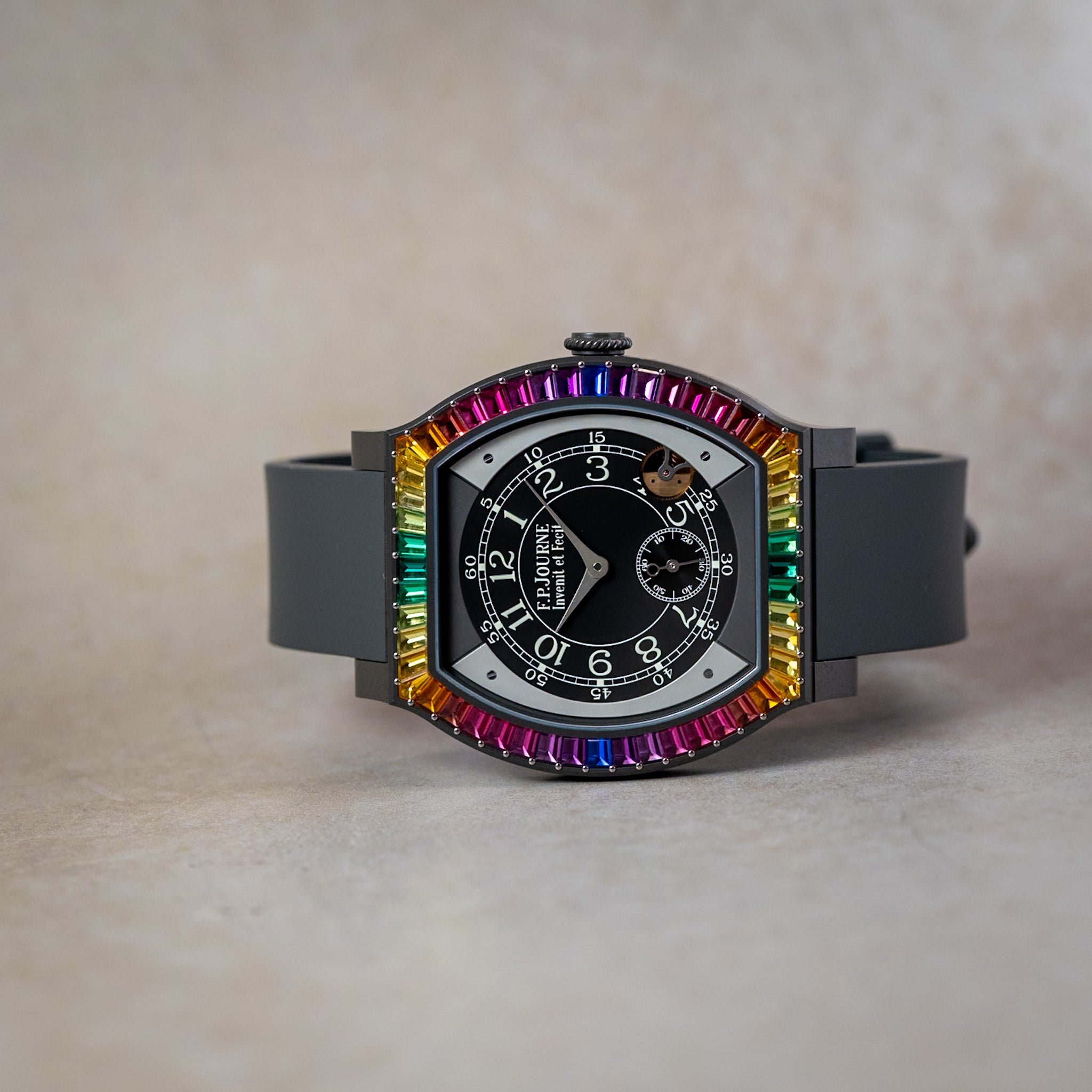 Watch with a colorful bezel and black face on a beige background