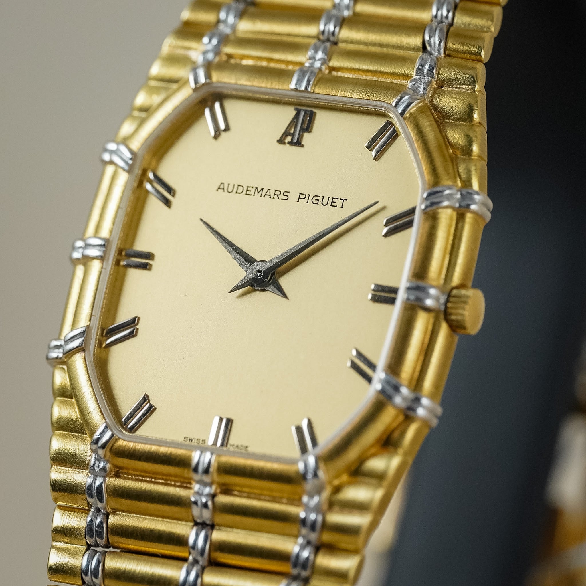 Close-up of an Audemars Piguet Bamboo in yellow gold and white gold with a gold dial, shot on a neutral cream background