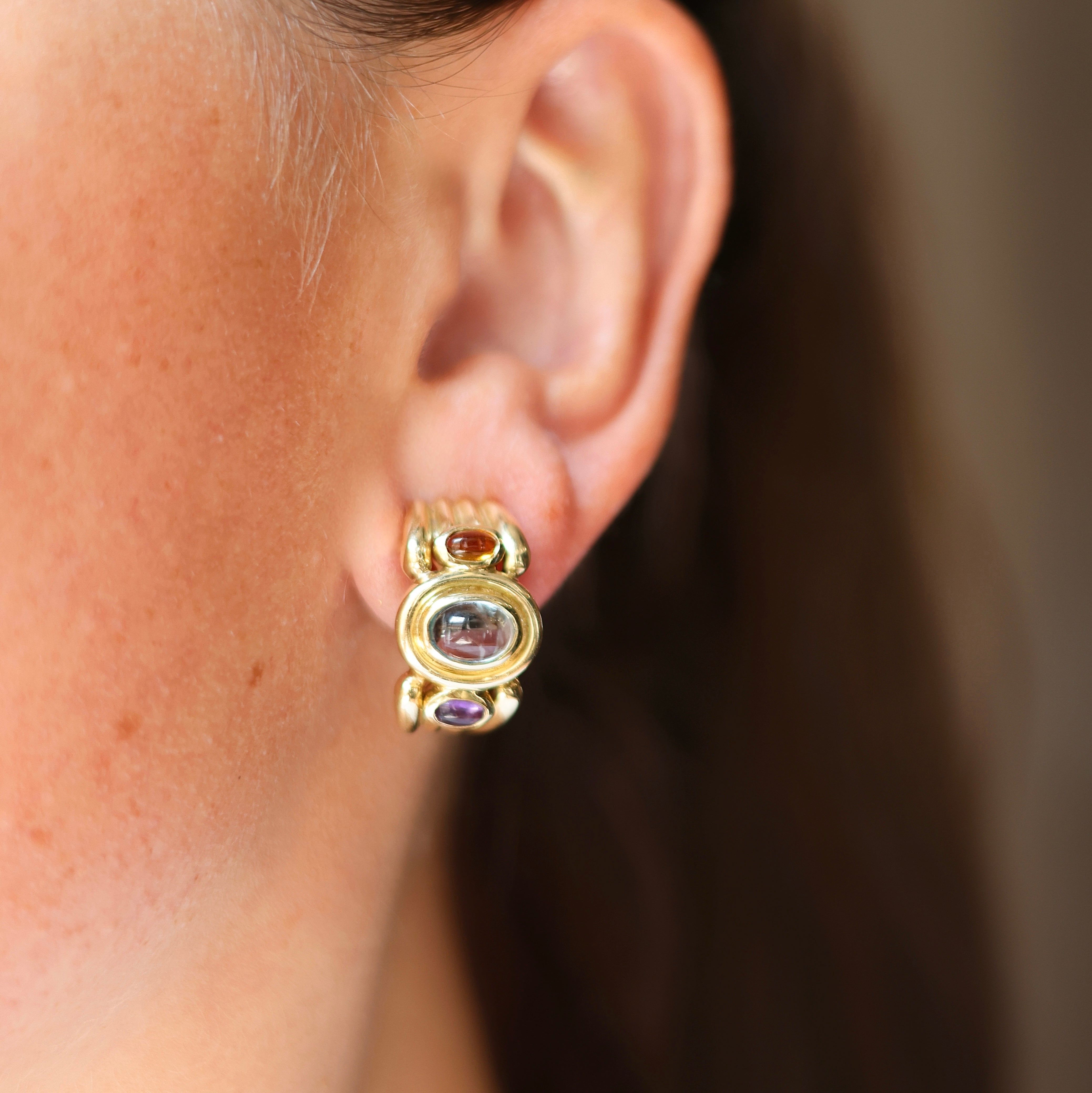 Vintage 14K yellow gold earrings with blue topaz, citrine, and amethyst cabochons on model 