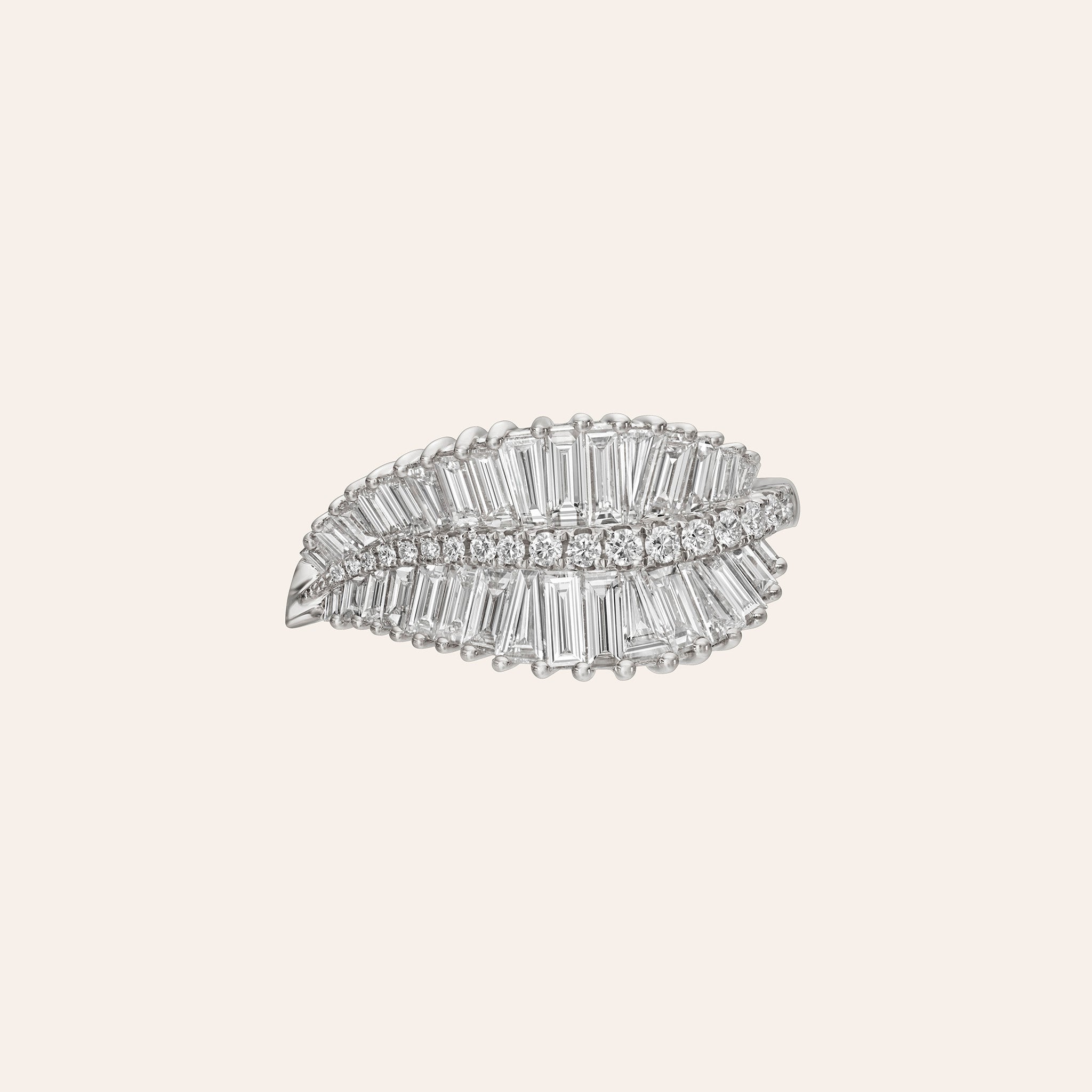A white gold leaf-shaped brooch embellished with baguette and round clear stones, centered on a solid light beige background.