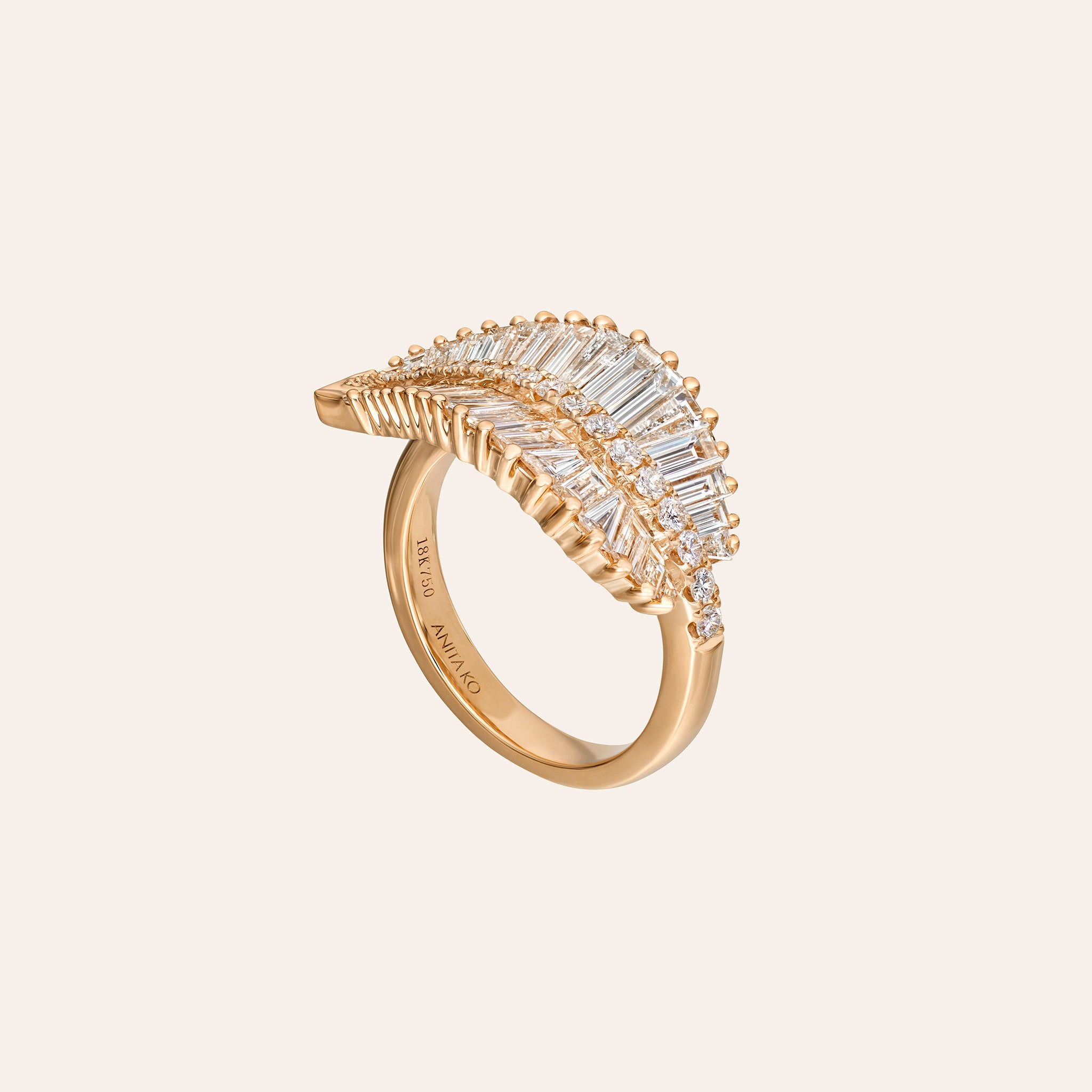 A rose gold ring featuring a leaf-shaped pavé setting with baguette and round clear stones, shown on a light beige background. The brand name 'ANITA KO'' is engraved on the inner band.