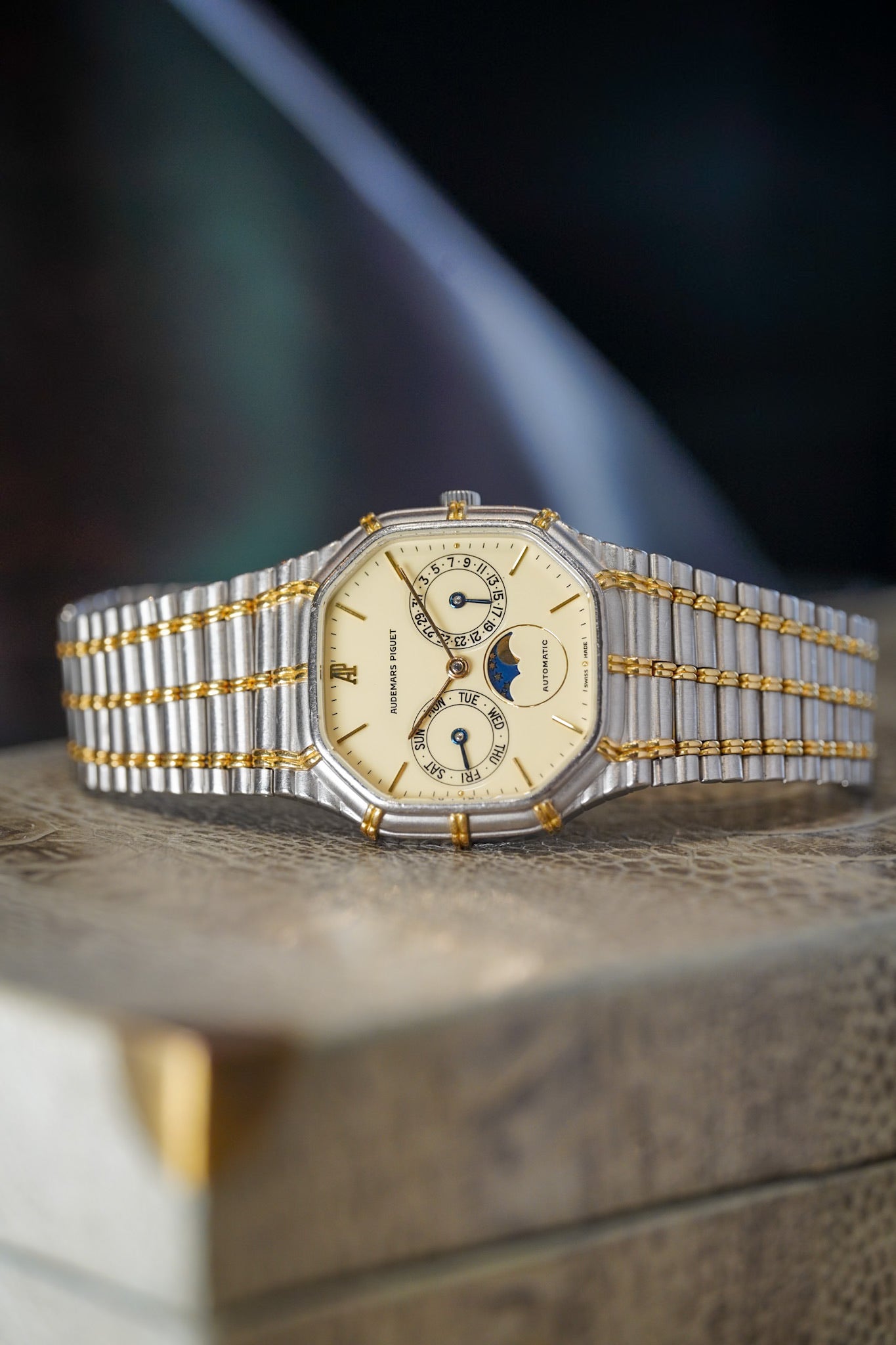 Luxury watch with gold and silver band on a dark background