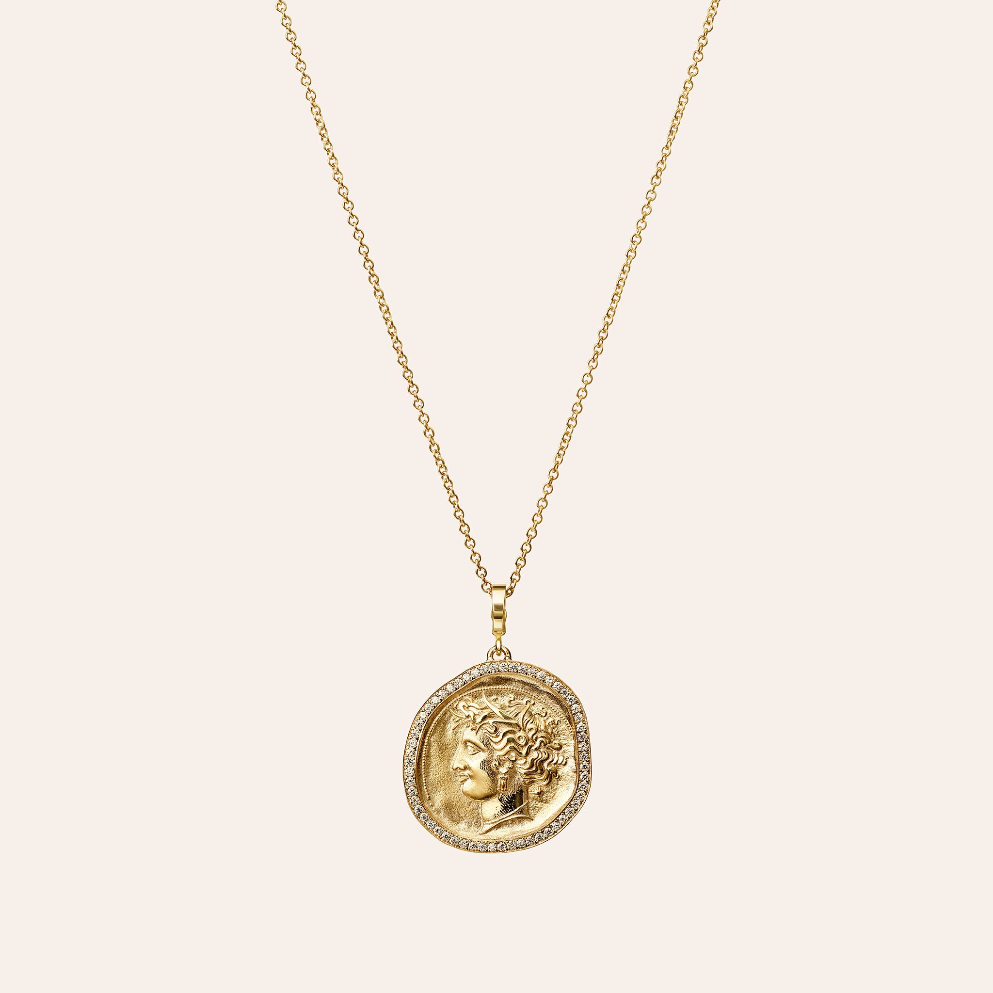 Āzlee Large Goddess Pavé Coin Charm in 18K yellow gold on a thin cable chain, on an ivory background