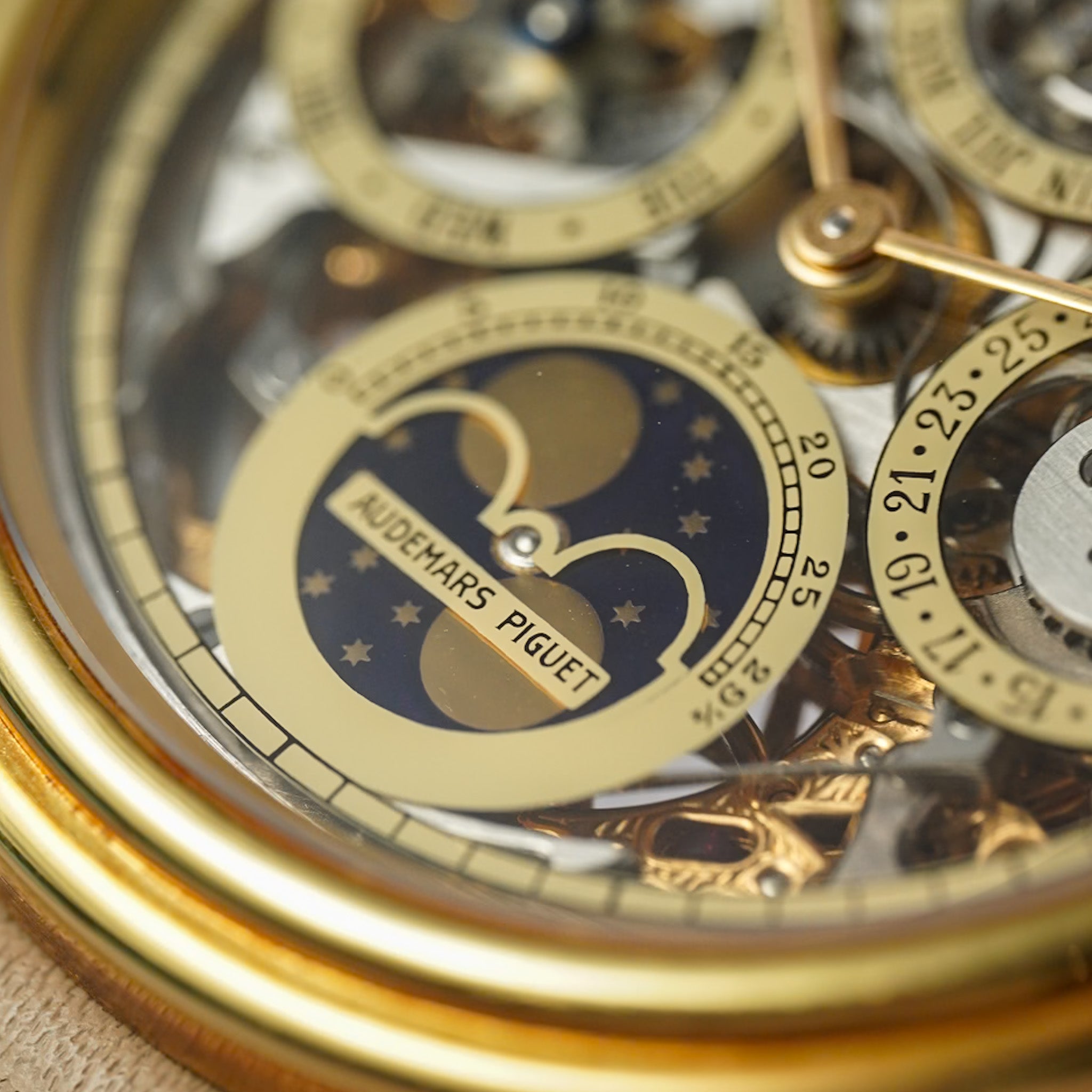 Close-up of a luxurious watch with 'Audemars Piguet' branding, showcasing intricate mechanical components.