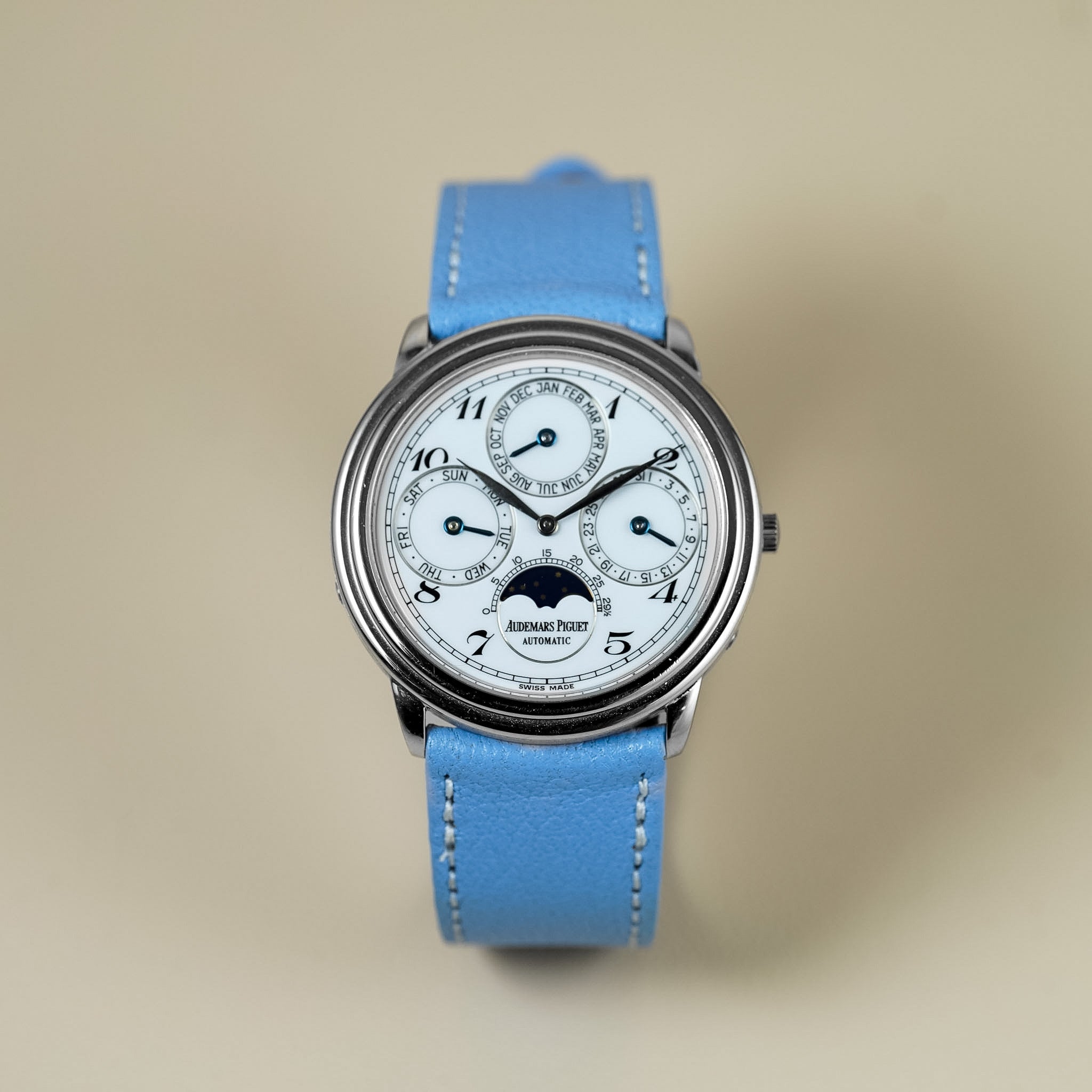 Wristwatch with blue strap on a beige background