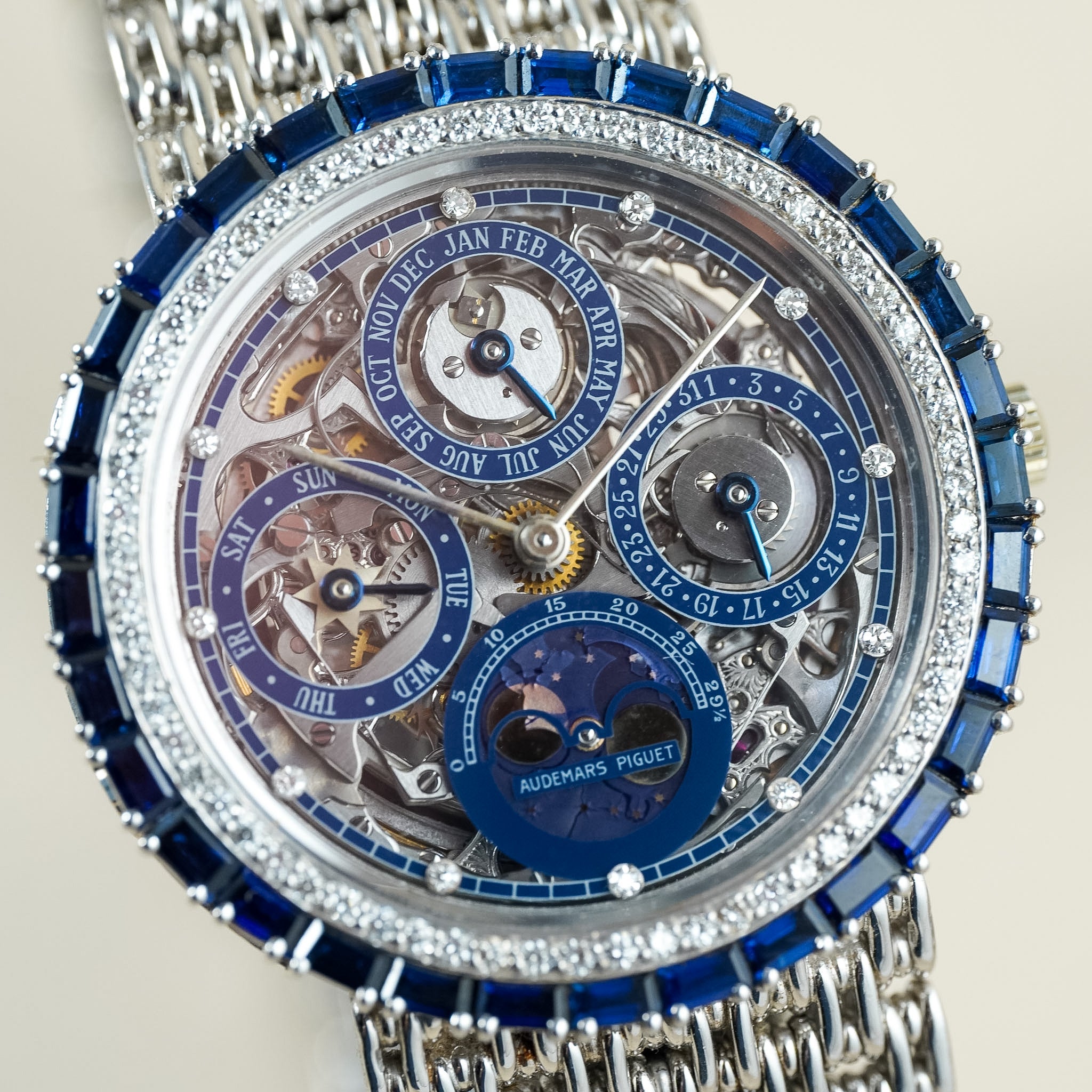 Luxury watch with intricate design and visible brand name on a neutral background
