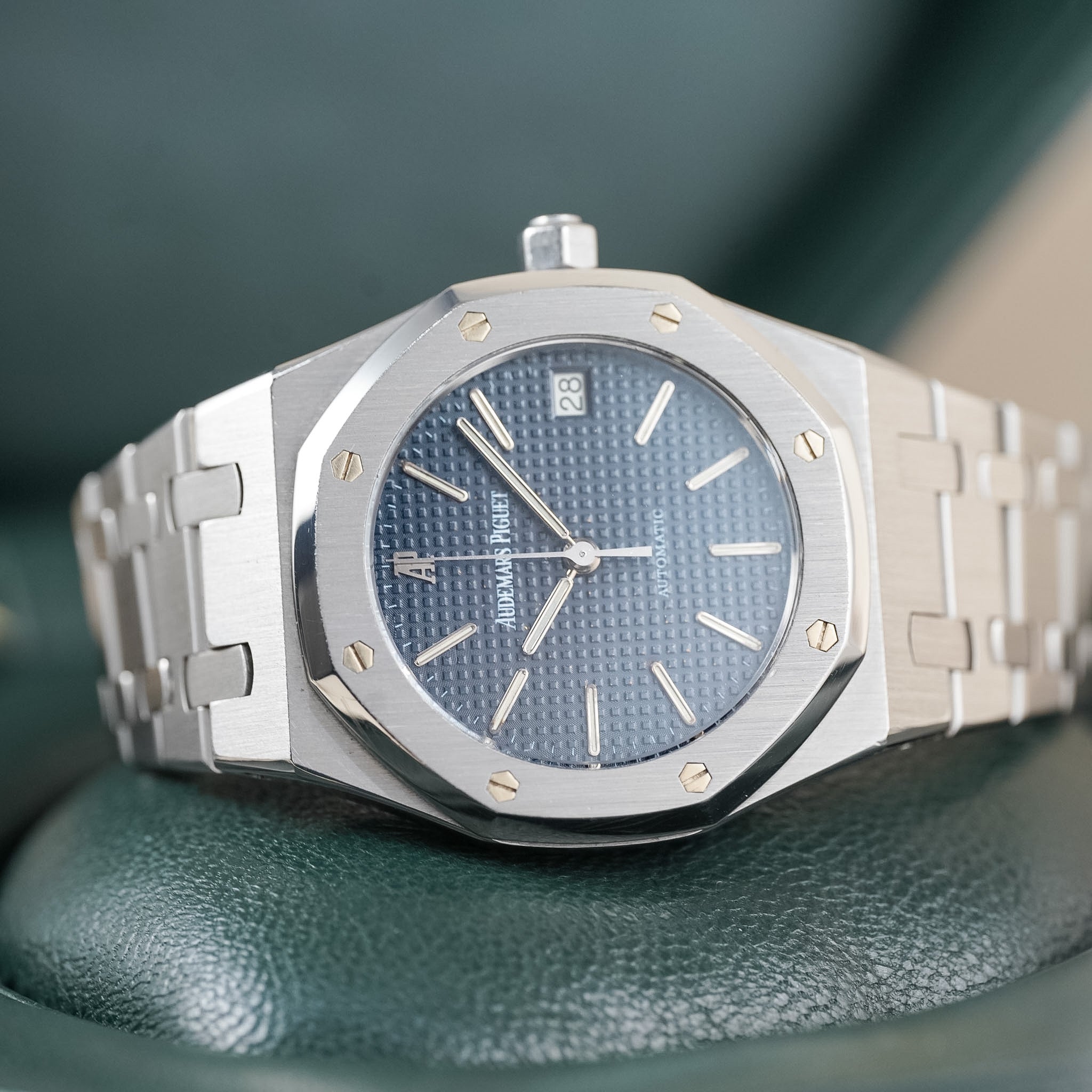 Blue dial steel watch laying sideways