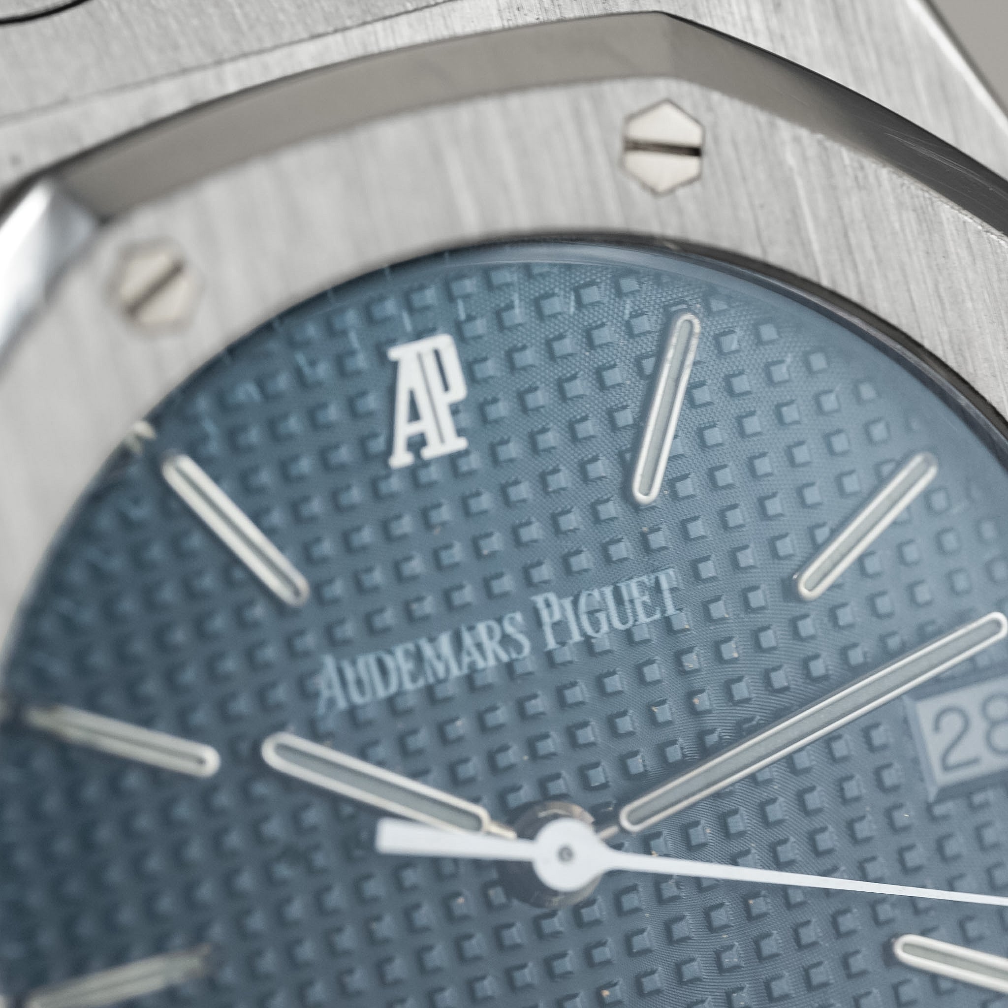 Close-up of an Audemars Piguet watch face with blue textured dial and silver accents.