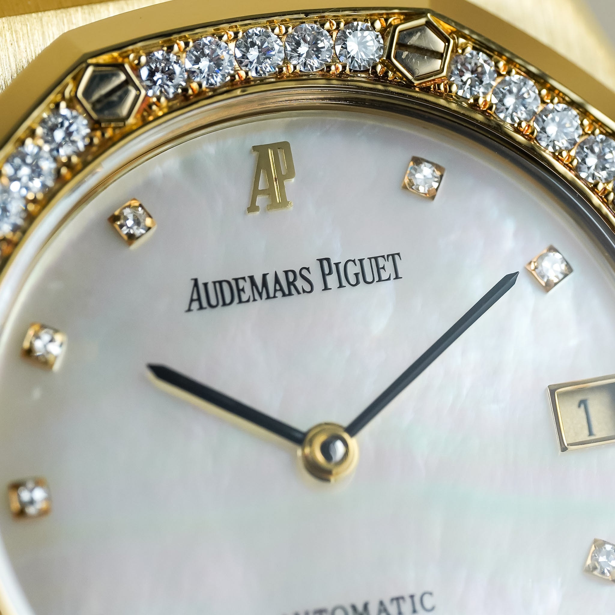 Close-up of an Audemars Piguet watch face with diamonds around the bezel.