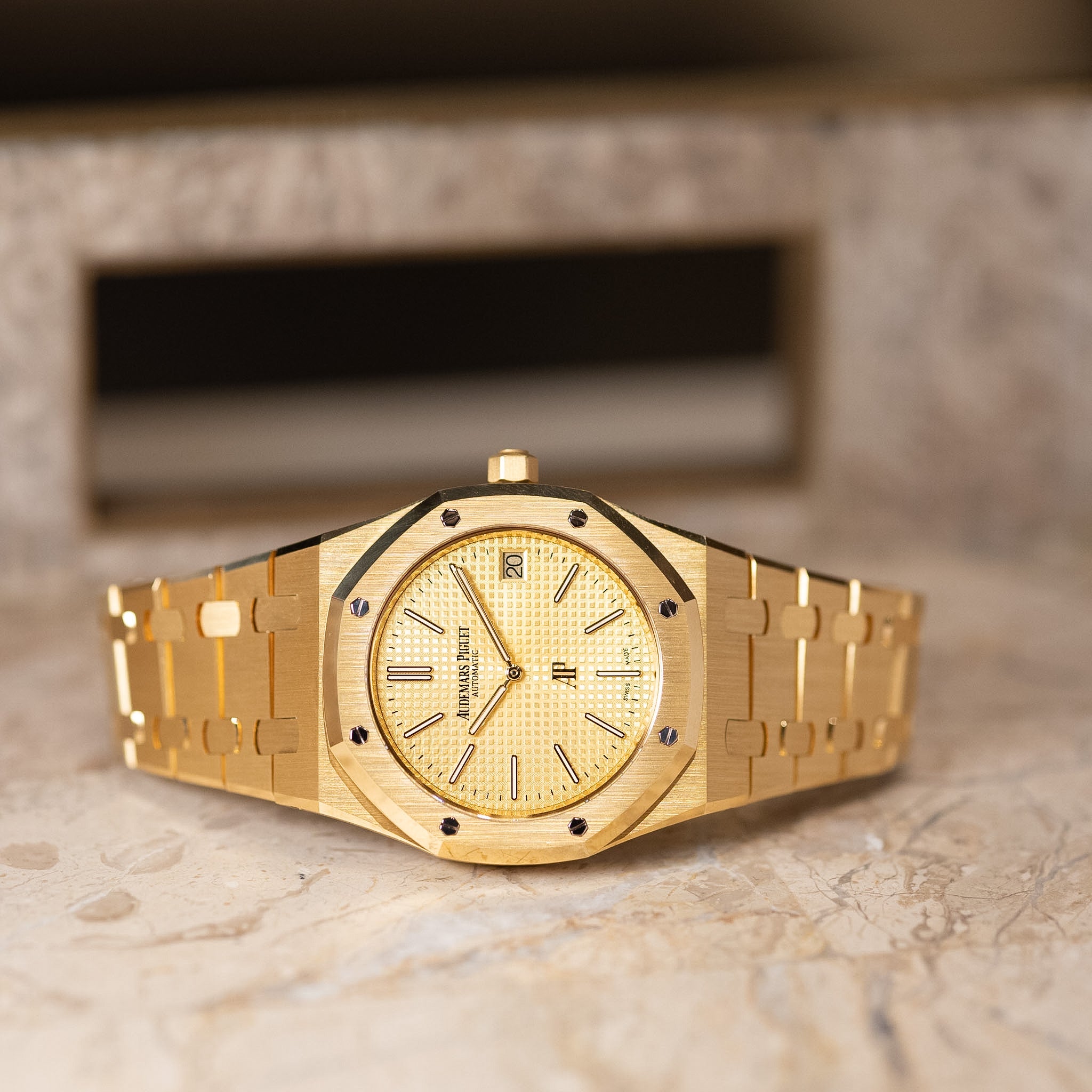 Gold watch with a detailed face on a marble surface