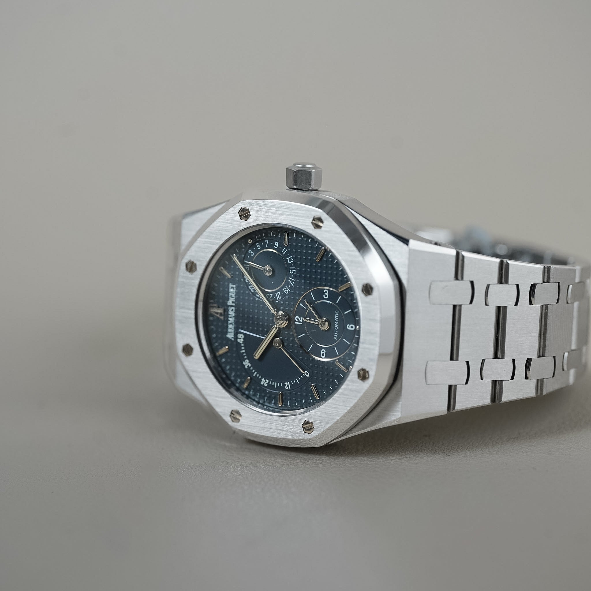 Silver watch with a blue face on a gray background