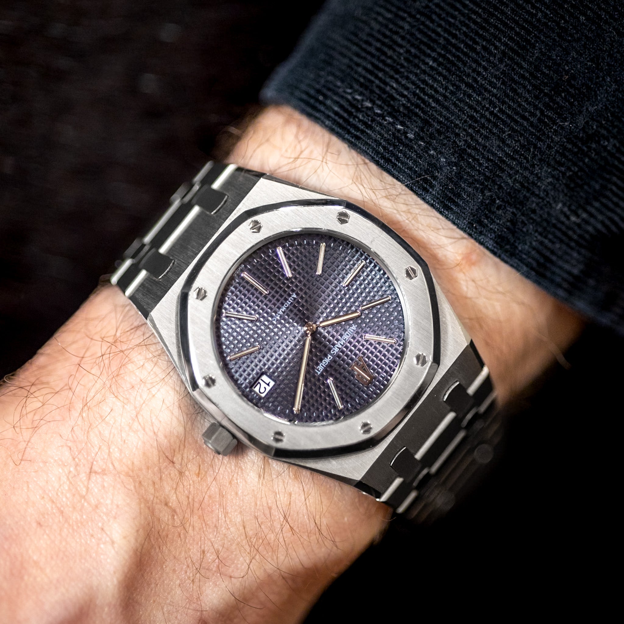 Close-up of a person's wrist wearing a silver watch with a dark face.