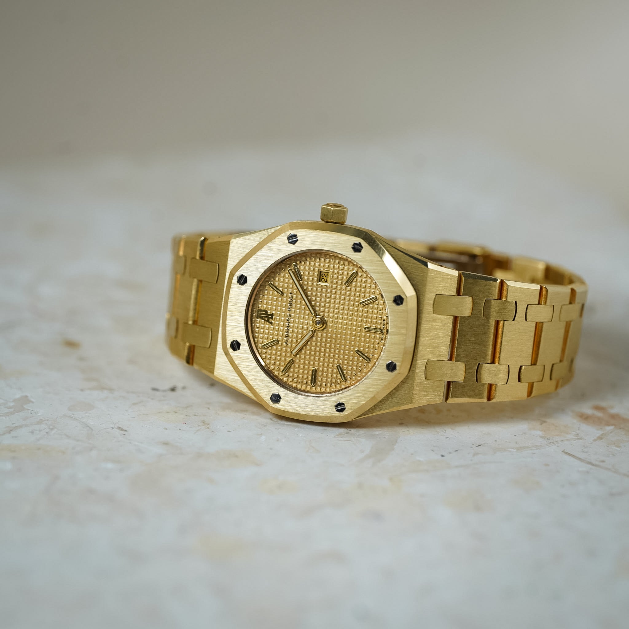 Gold wristwatch on a light marble surface