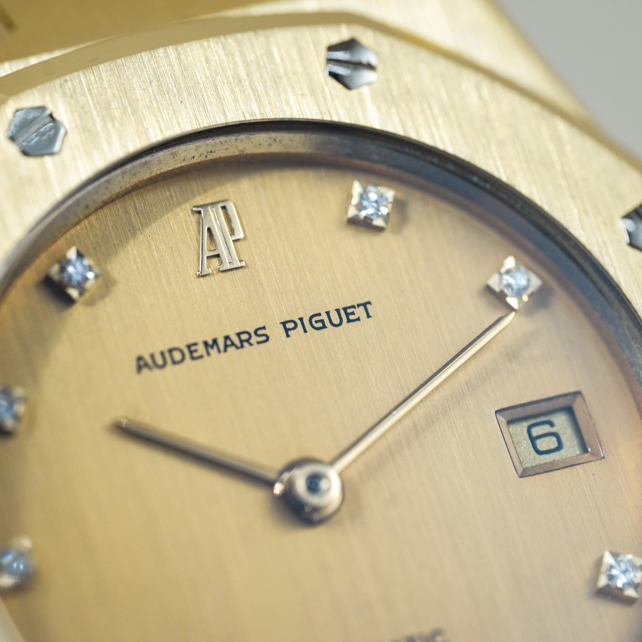 Close-up of a gold Audemars Piguet watch face with diamonds on the bezel.