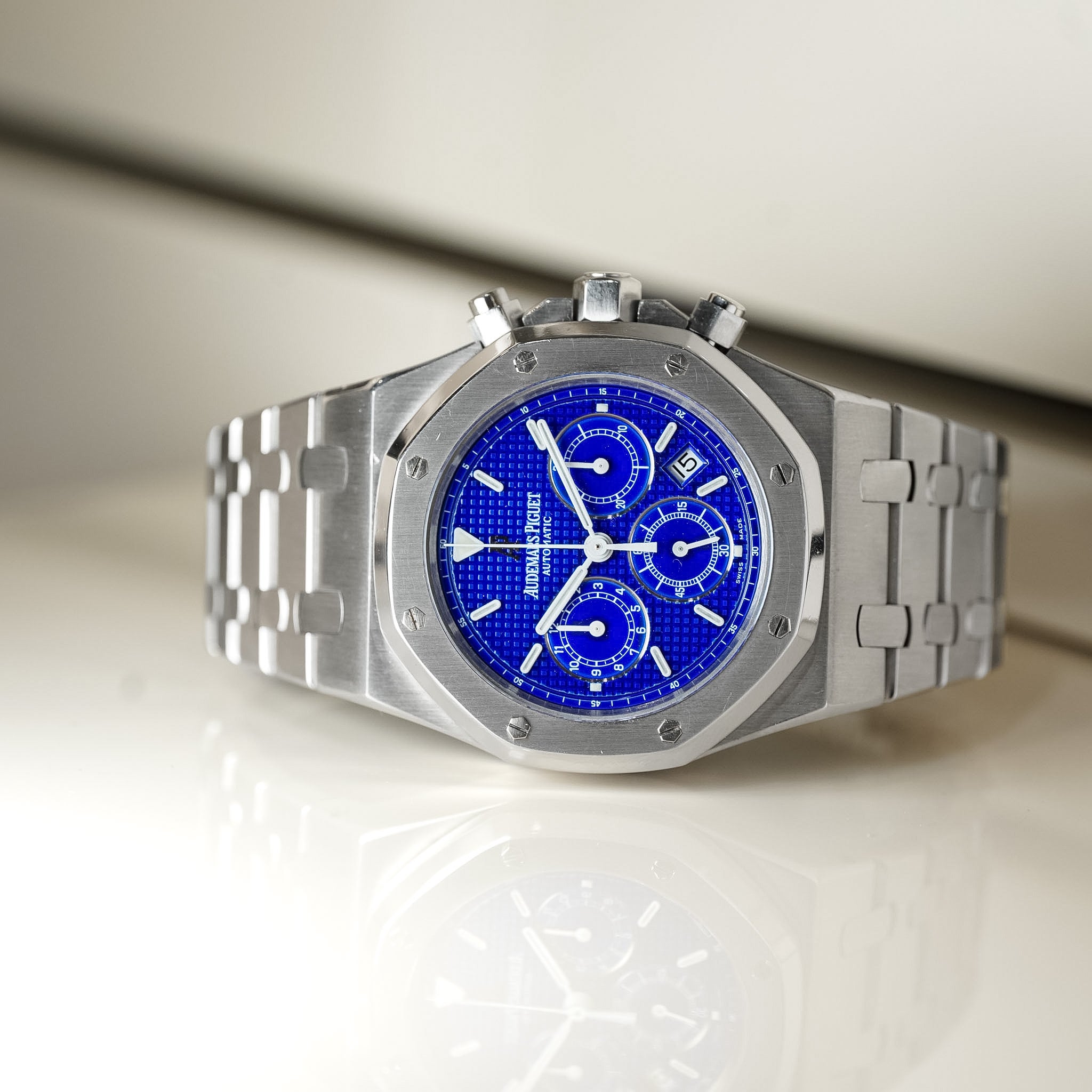 Silver watch with a blue face on a light background